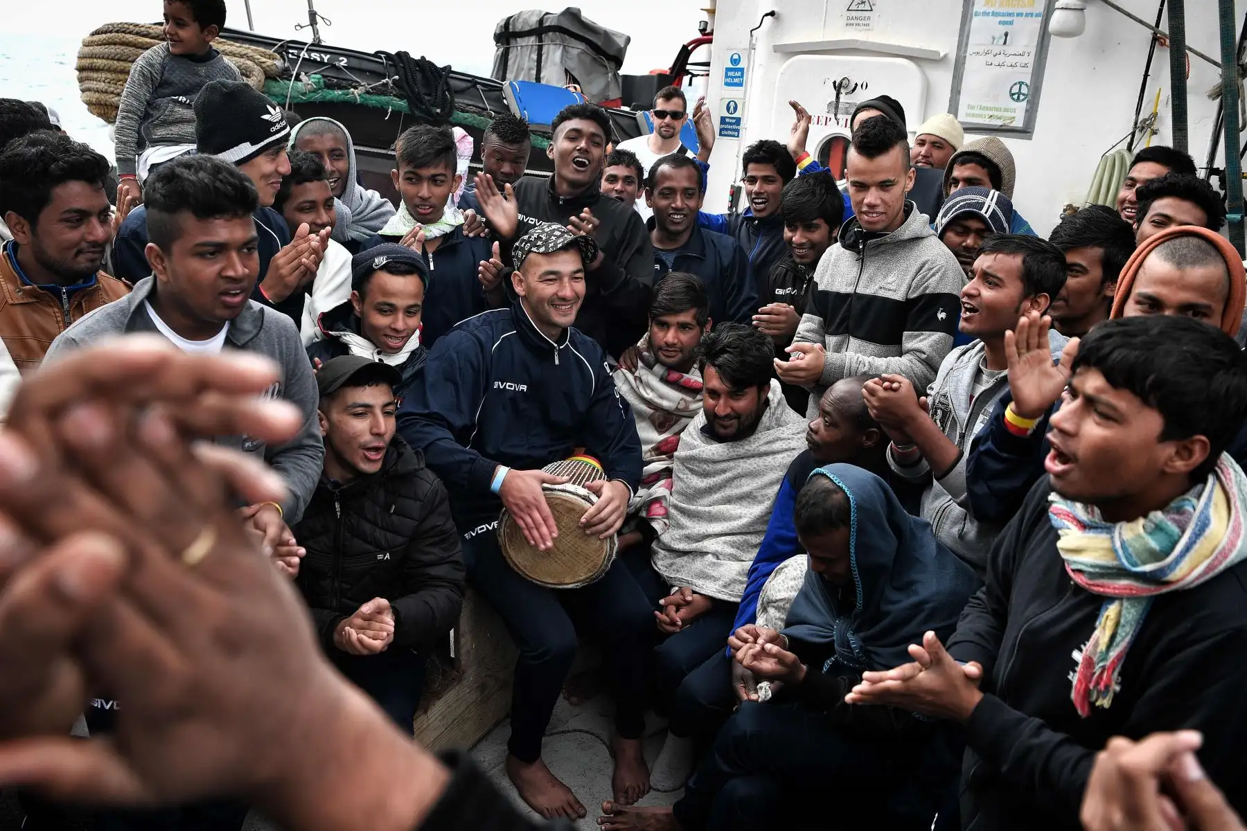 Los inmigrantes tocan música a bordo de MV Aquarius, un buque de rescate contratado por SOS-Mediterranee y Médicos Sin Fronteras (MSF), en el mar Mediterráneo, entre Libia e Italia.  Foto: AFP