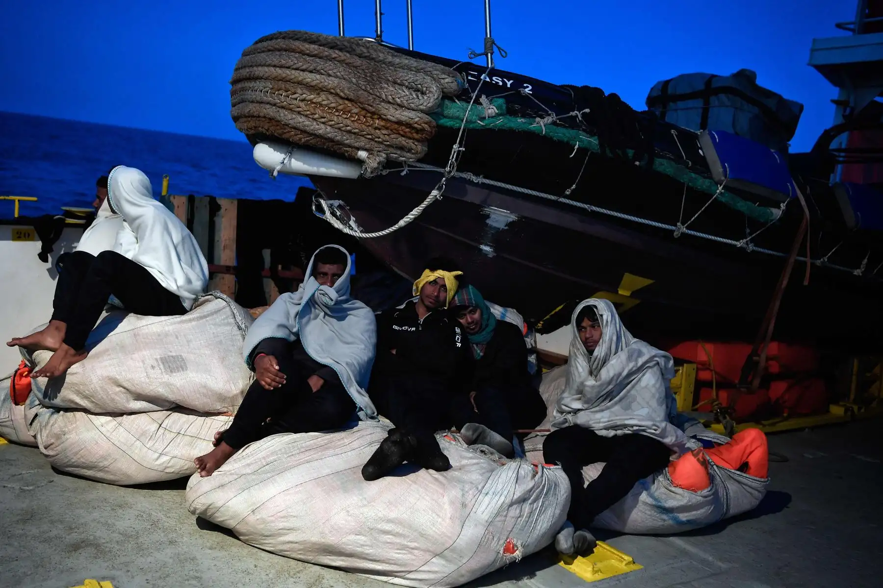 Los inmigrantes se sientan a bordo de MV Aquarius, un buque de rescate contratado por SOS-Mediterranee y Médicos Sin Fronteras, en el mar Mediterráneo, mientras viajan con destino a Italia. AFP