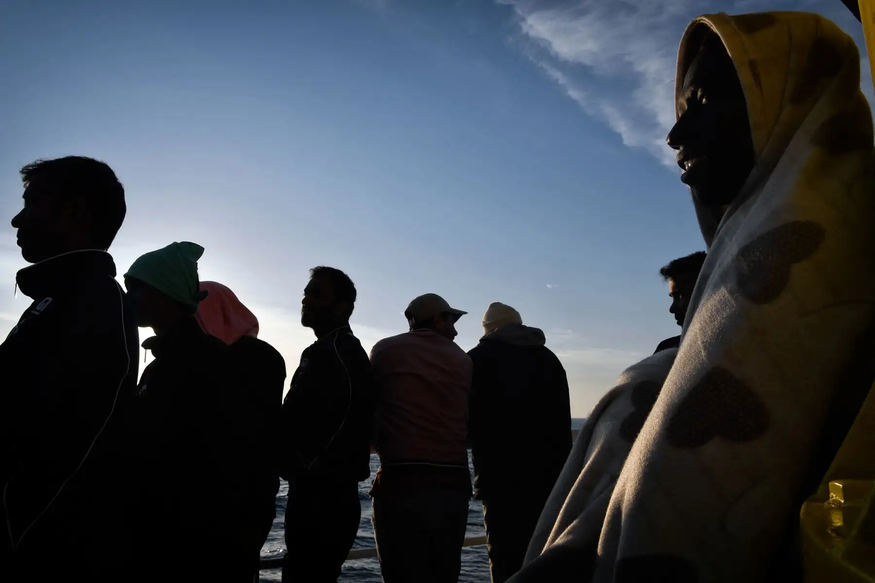 Los migrantes observan la costa siciliana desde el MV Aquarius, un buque de rescate contratado por las organizaciones humanitarias SOS Mediterranee y Médicos Sin Fronteras. AFP