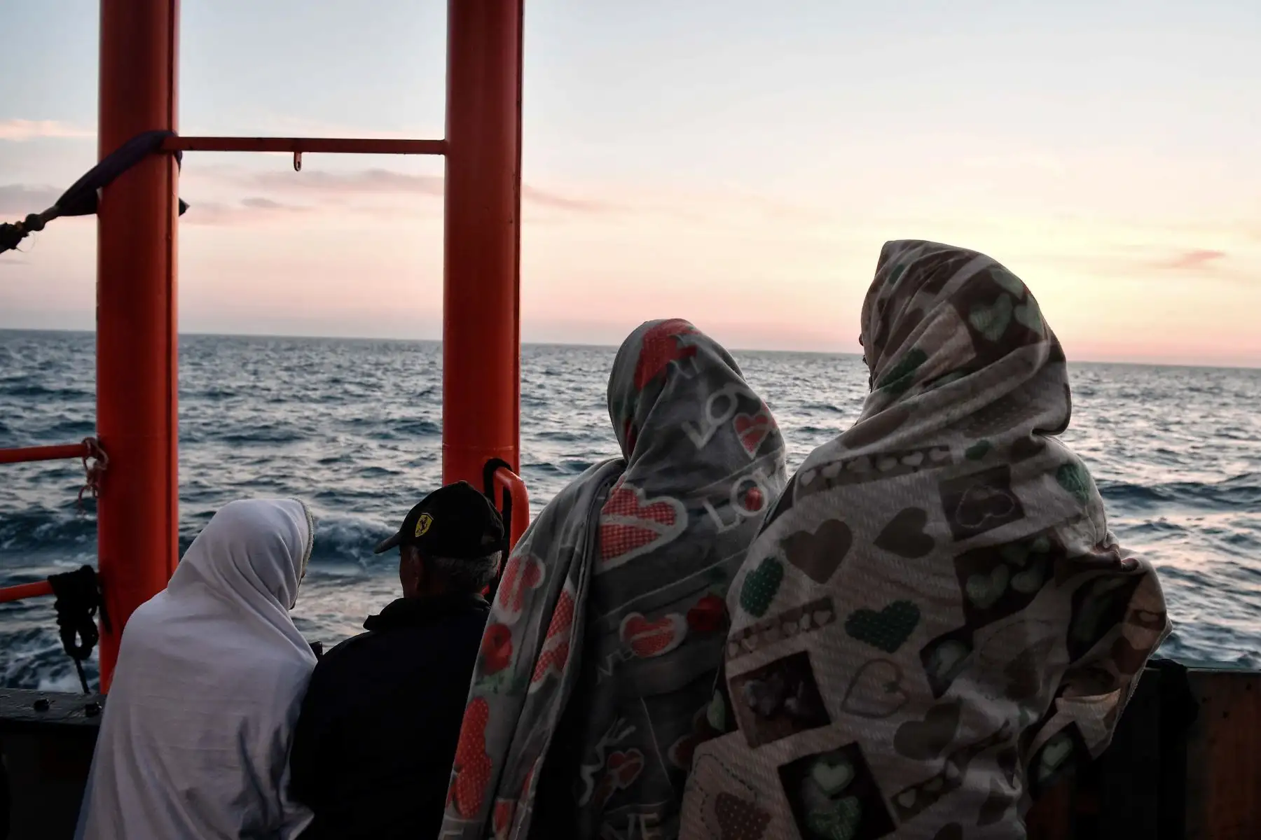Los migrantes se paran en la cubierta del MV Aquarius, un buque de rescate fletado por SOS-Mediterranee y Médicos Sin Fronteras, cuando se acerca a la costa italiana. AFP