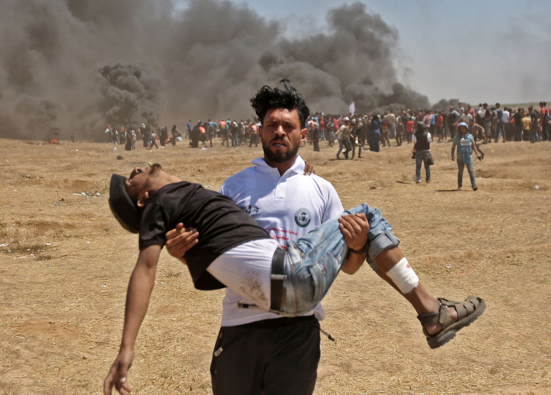 Un palestino carga a un manifestante herido durante los enfrentamientos con las fuerzas israelíes cerca de la frontera entre la franja de Gaza e Israel. AFP