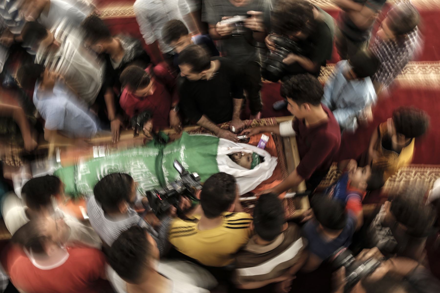 Detenidos palestinos rodean el cuerpo de Yazan al-Tubasi, asesinado durante enfrentamientos en Gaza el día anterior. AFP
