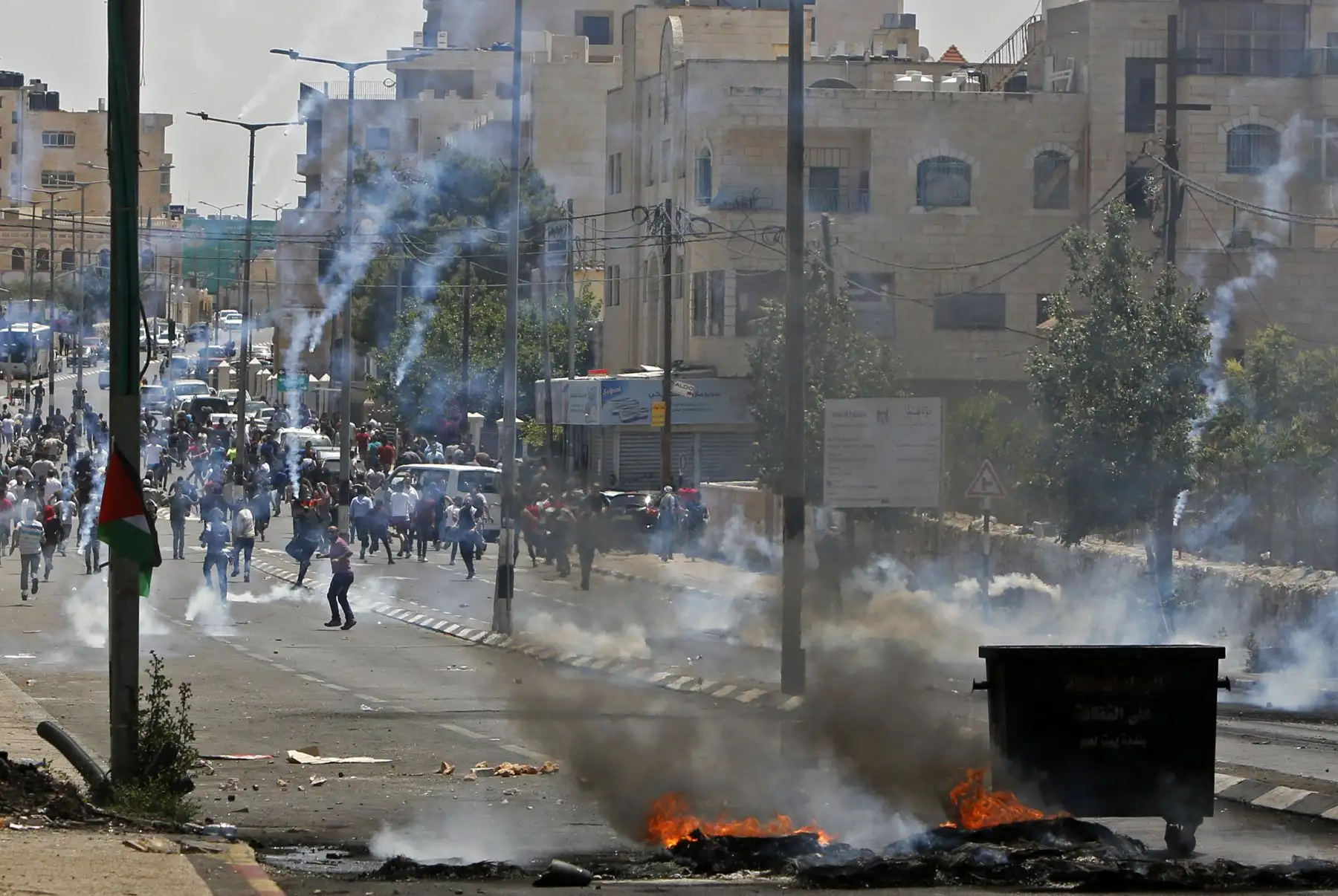 Los palestinos arrojan piedras contra las fuerzas de seguridad israelíes durante los enfrentamientos después de una protesta por el 70 aniversario de Nakba, también conocido como Día de la Catástrofe en 1948, y contra el traslado de su embajada de Tel Aviv a Jerusalén, en la entrada principal de la ciudad ocupada de Cisjordania. AFP