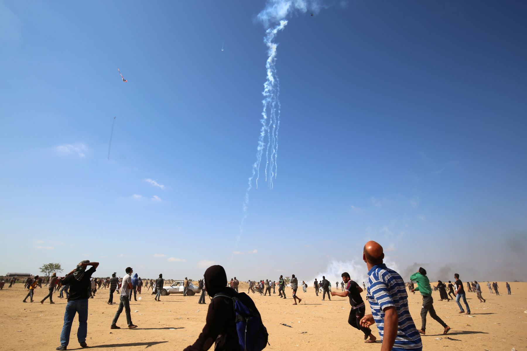 Manifestantes palestinos observan la caída de latas de gas lacrimógeno arrojadas por un avión no tripulado israelí durante enfrentamientos cerca de la frontera con Israel al este de Khan Younis en el sur de la Franja de Gaza. AFP
