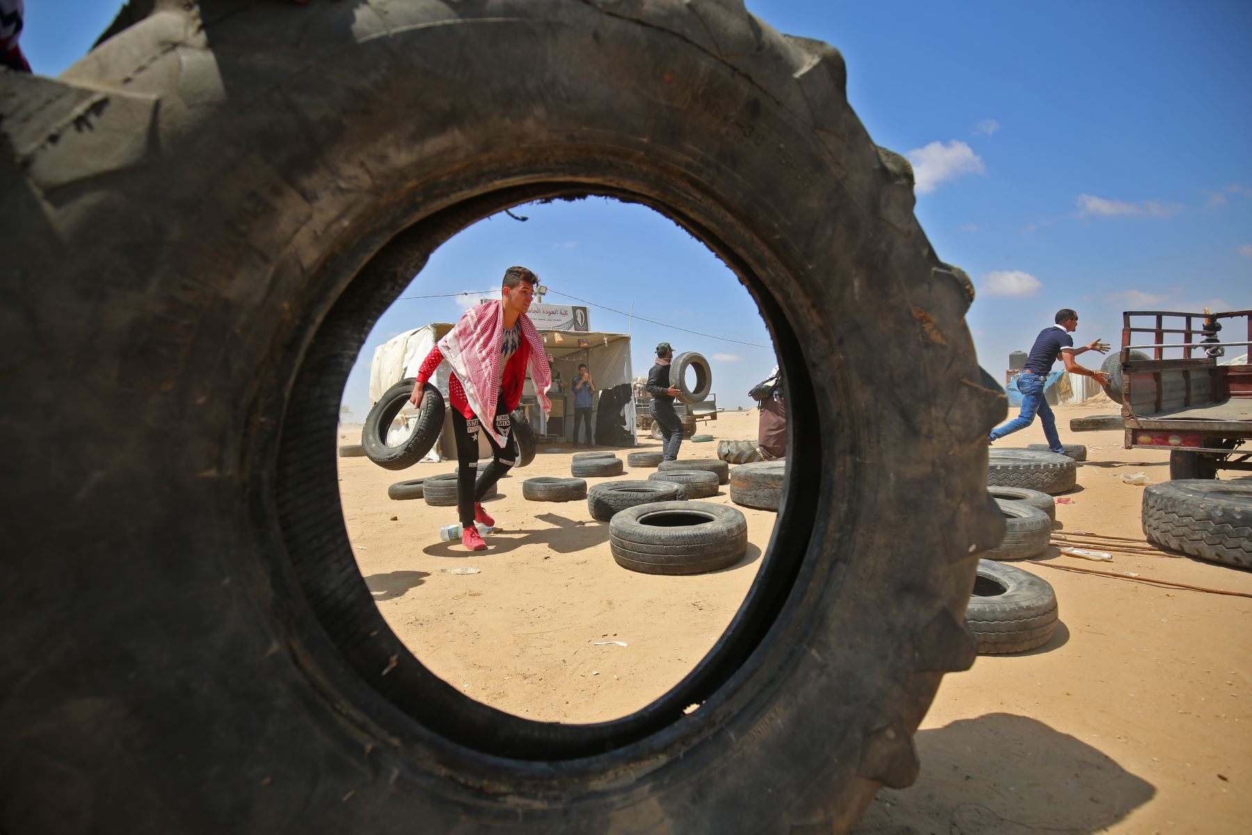 Un palestino recoge neumáticos para llevarlos hacia una barricada improvisada antes de quemarlos durante las manifestaciones cerca de la frontera con Israel, al este de Khan Younis en el sur de la Franja de Gaza. AFP
