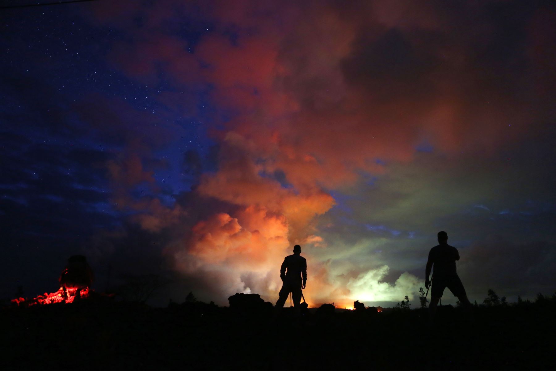 Los fotógrafos capturan como la lava de las fisuras activas ilumina los gases volcánicos del volcán Kilauea, en Hawái. Foto: AFP.