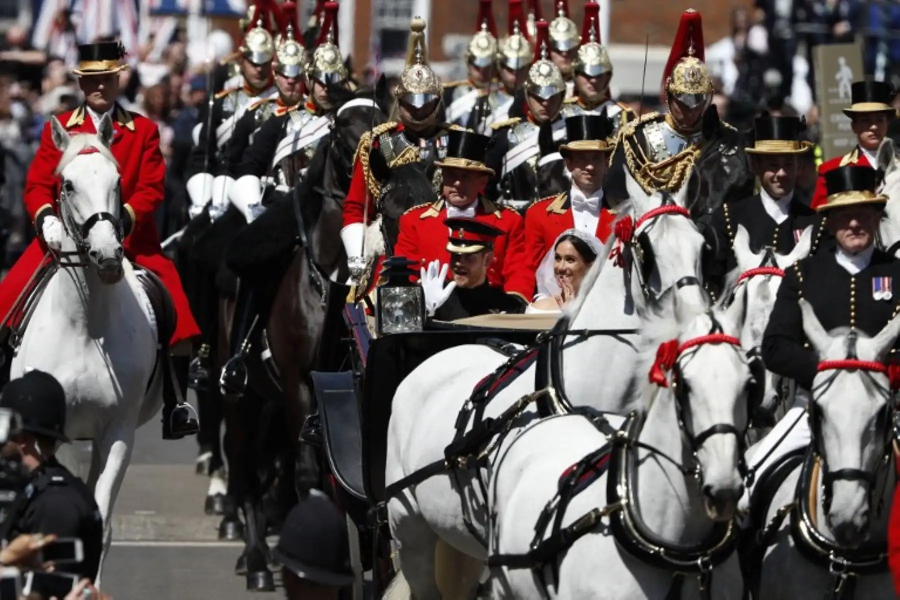 El príncipe Harry, duque de Sussex y su esposa Meghan, duquesa de Sussex, saludan desde el vagón de Ascot Landau durante su procesión de carruajes en la calle principal de Windsor.Foto:AFP