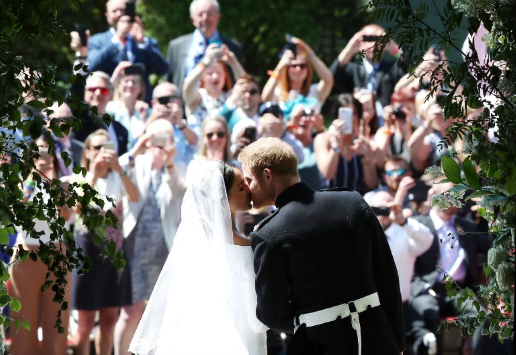 El príncipe Harry de Gran Bretaña, duque de Sussex besa a su esposa Meghan, duquesa de Sussex cuando salen de la puerta oeste de la capilla de San Jorge, el castillo de Windsor, en Windsor.Foto:AFP