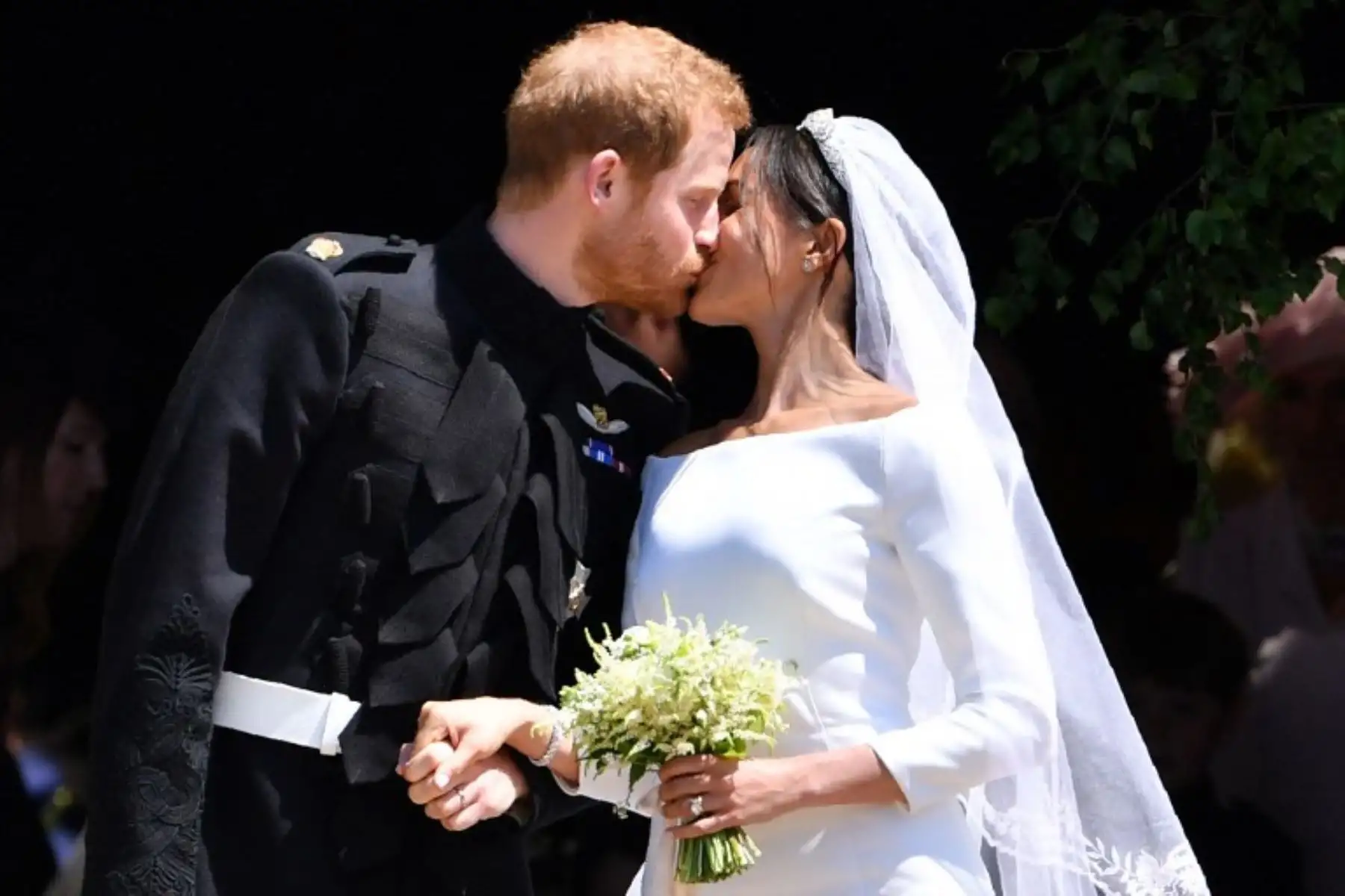 El príncipe Harry de Gran Bretaña, duque de Sussex besa a su esposa Meghan, duquesa de Sussex cuando salen de la puerta oeste de la capilla de San Jorge, el castillo de Windsor.Foto:AFP
