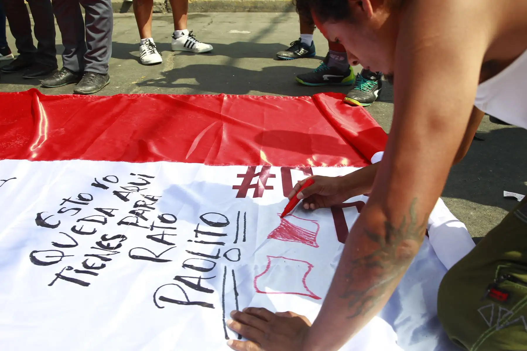 Hinchas firman “Bandera Guerrera”, confeccionada por los comerciantes de Gamarra. Foto: ANDINA/Eddy Ramos.