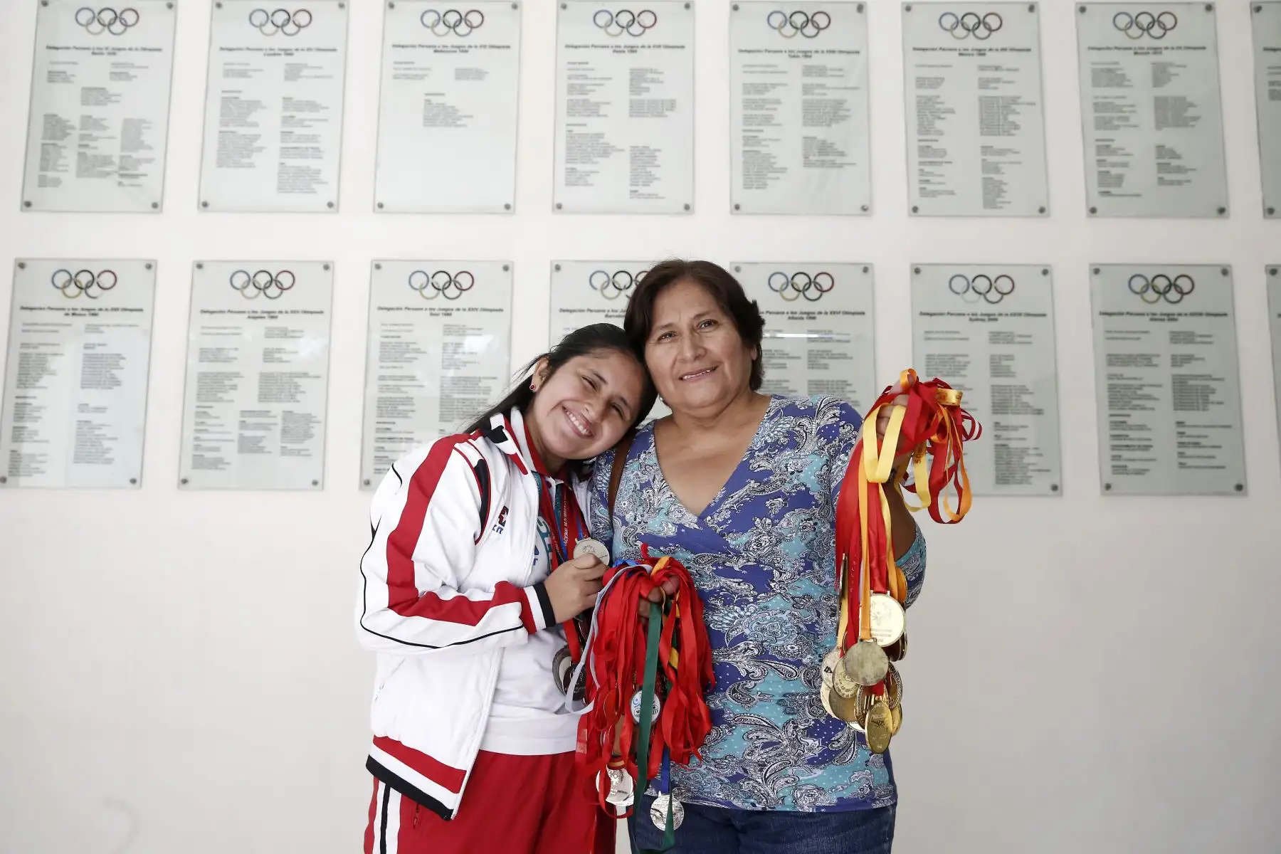 Claudia Calderón posa junto a su madre, quien es su apoyo más grande y muestra orgullosa las más de 70 medallas que obtuvo nuestra deportista.  Foto: ANDINA/Melina Mejía.