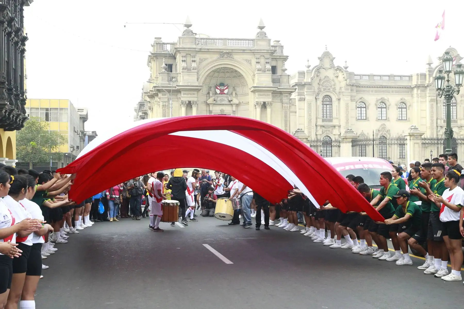Hinchas peruanos participan en "Banderazo por la Blanquirroja" en la Plaza Mayor, donde las personas dejan un mensaje de aliento a la selección en una bandera gigante. Foto: ANDINA/Eddy Ramos.