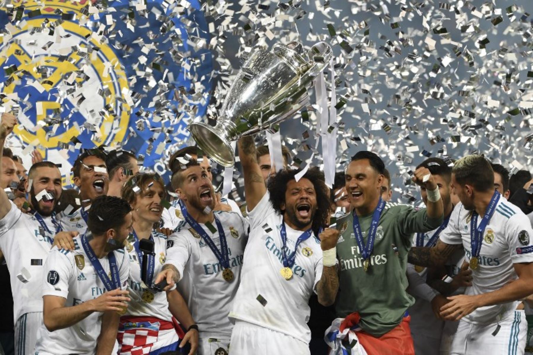 El defensor brasileño del Real Madrid Marcelo levanta el trofeo mientras los jugadores del Real Madrid celebran ganar el partido final de la UEFA. Foto: AFP