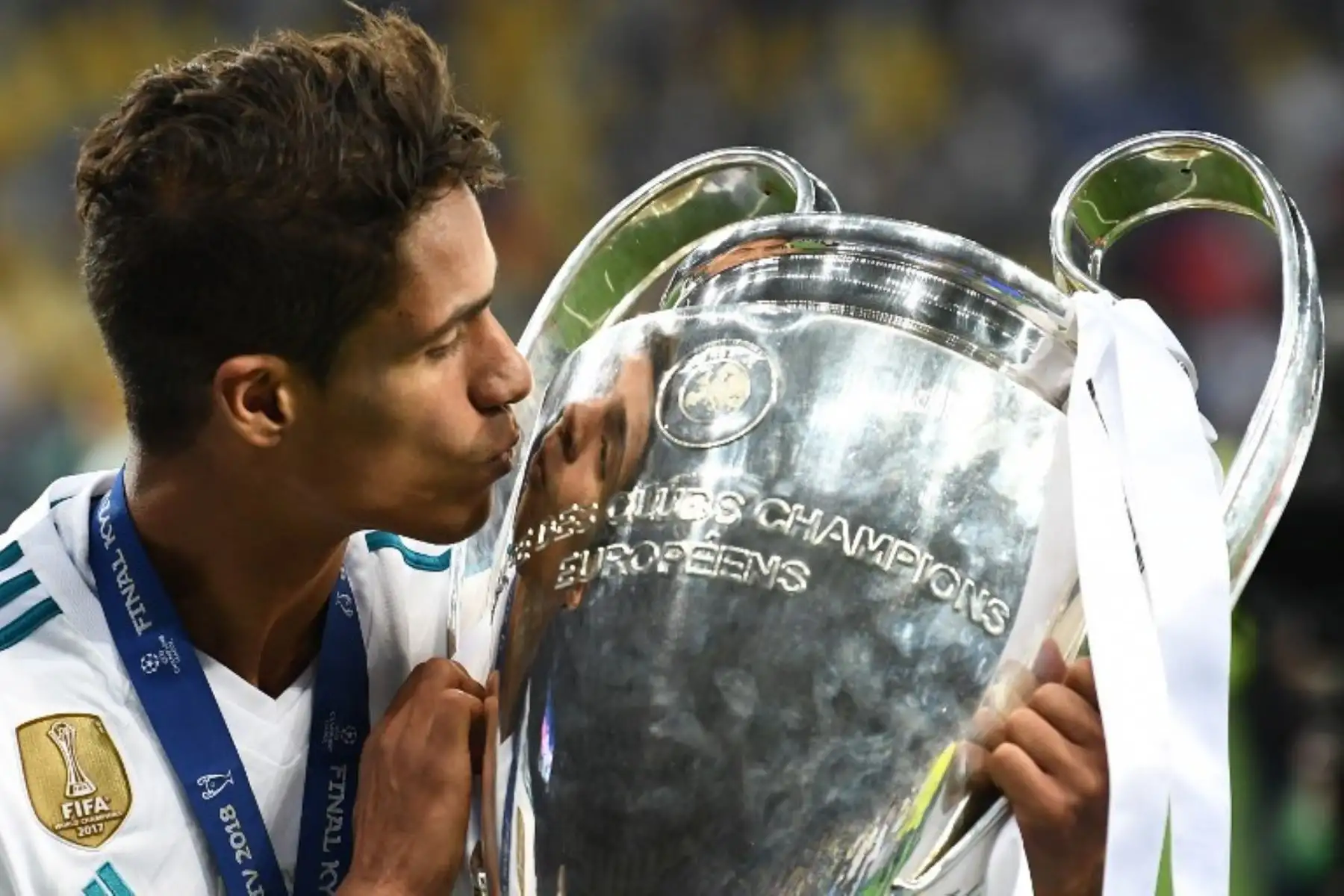 El defensa francés del Real Madrid Raphael Varane besa el trofeo mientras posa después de ganar el partido de fútbol final de la UEFA. Foto: AFP