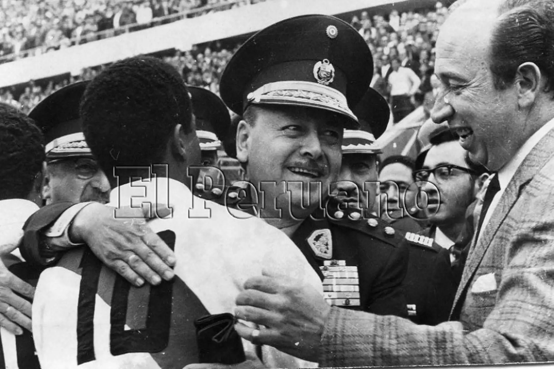 Presidente Juan Velasco Alvarado abraza a un jugador de la selección peruana de fútbol tras un partido.