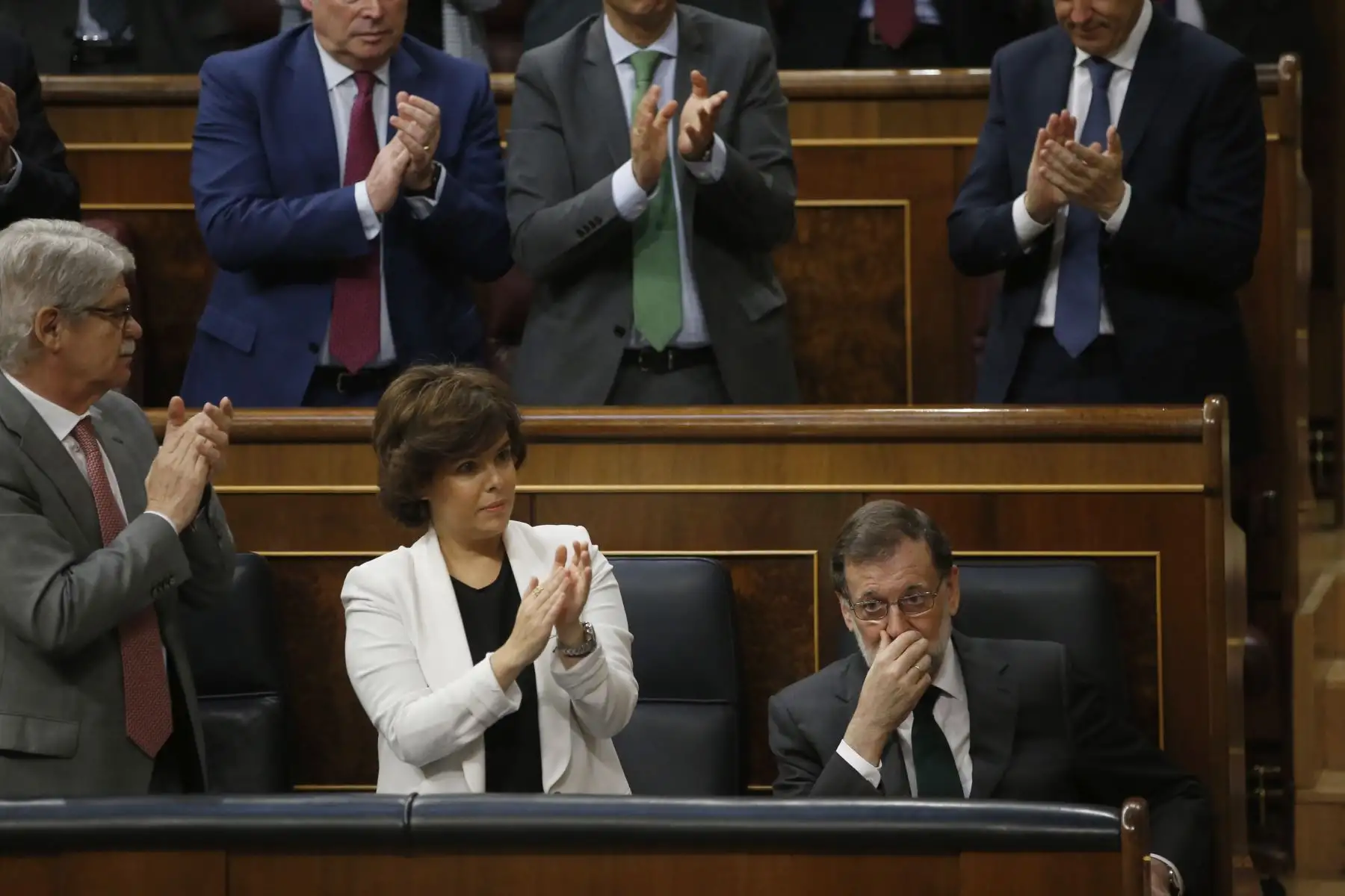 El presidente del Gobierno, Mariano Rajoy (d), es aplaudido por la vicepresidenta, Soraya Sáenz de Santamaría y el ministro de Exteriores, Alfonso Dastis (i), tras su intervención en la segunda jornada de la moción de censura presentada por el PSOE. EFE/Javier Lizón