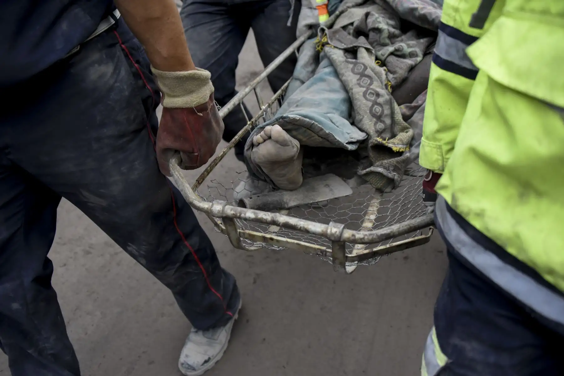 Los agentes policiales trasladan a una víctima en el pueblo cubierto de ceniza de San Miguel Los Lotes, en el departamento de Escuintla, a 35 km al suroeste de Ciudad de Guatemala. Foto: AFP.