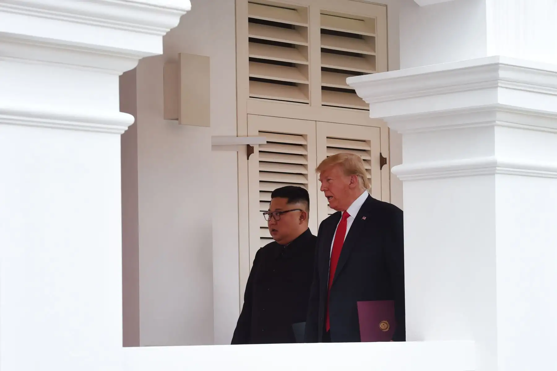 El presidente de los Estados Unidos, Donald J. Trump (i), y el líder norcoreano, Kim Jong-un (d), hablan durante una cumbre histórica, en los jardines del hotel Capella en la isla de Sentosa (Singapur). Foto: AFP