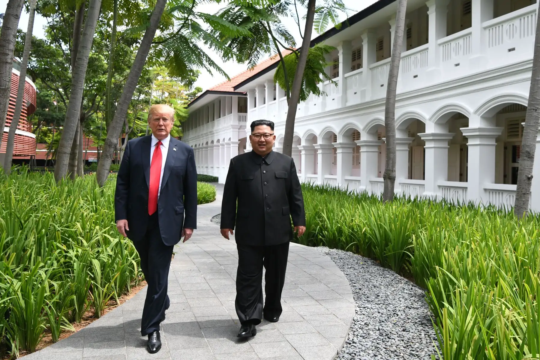El presidente de los Estados Unidos, Donald J. Trump (i), y el líder norcoreano, Kim Jong-un (d), hablan durante una cumbre histórica, en los jardines del hotel Capella en la isla de Sentosa (Singapur). Foto: AFP