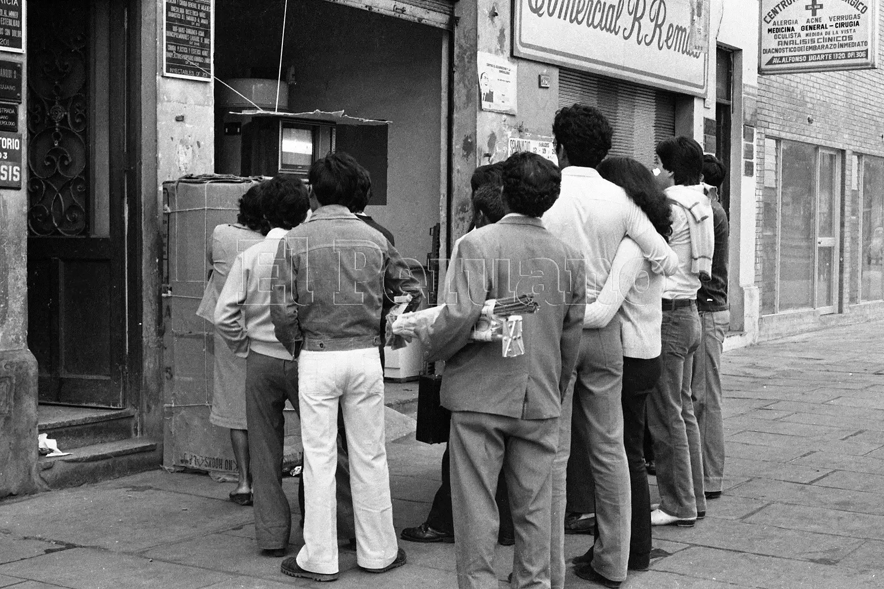 Un grupo de personas sigue la transmisión en directo del partido entre Perú y Camerún en el Mundial España 82.   Foto: ANDINA/archivo