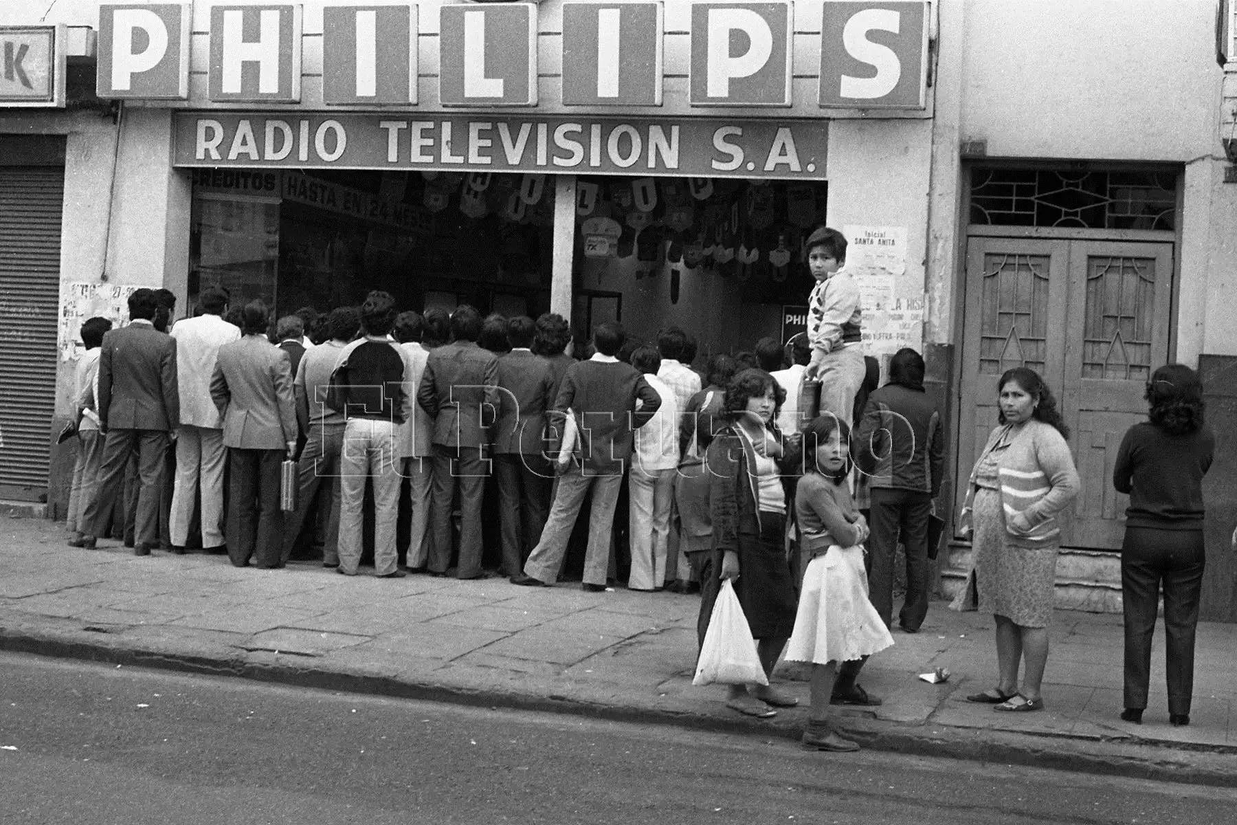 Un grupo de personas sigue la transmisión en directo del partido entre Perú y Camerún en el Mundial España 82.  Foto: ANDINA/archivo