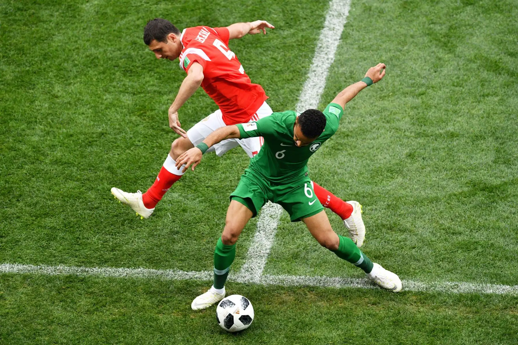 El defensor de Rusia Andrey Semenov  y el defensor de Arabia Saudita Mohammed Al-Breik compiten por el balón durante el partido de fútbol del Grupo A de la Copa Mundial Rusia 2018 entre Rusia y Arabia Saudita en el Estadio Luzhniki en Moscú. AFP