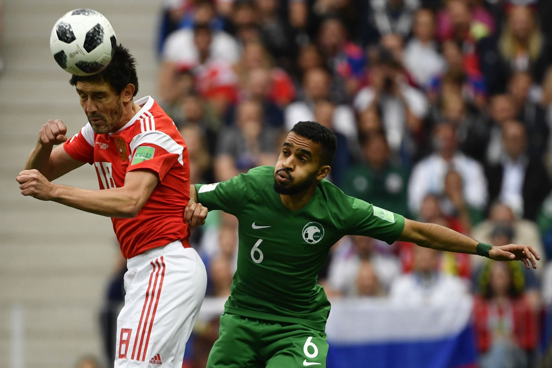 El centrocampista de Russia Yury Zhirkov  y el defensor de KSA Arabia Saudita Mohammed Al-Breik compiten durante el partido de fútbol de la Copa Mundial Rusia 2018 A entre Rusia y Arabia Saudita. AFP
