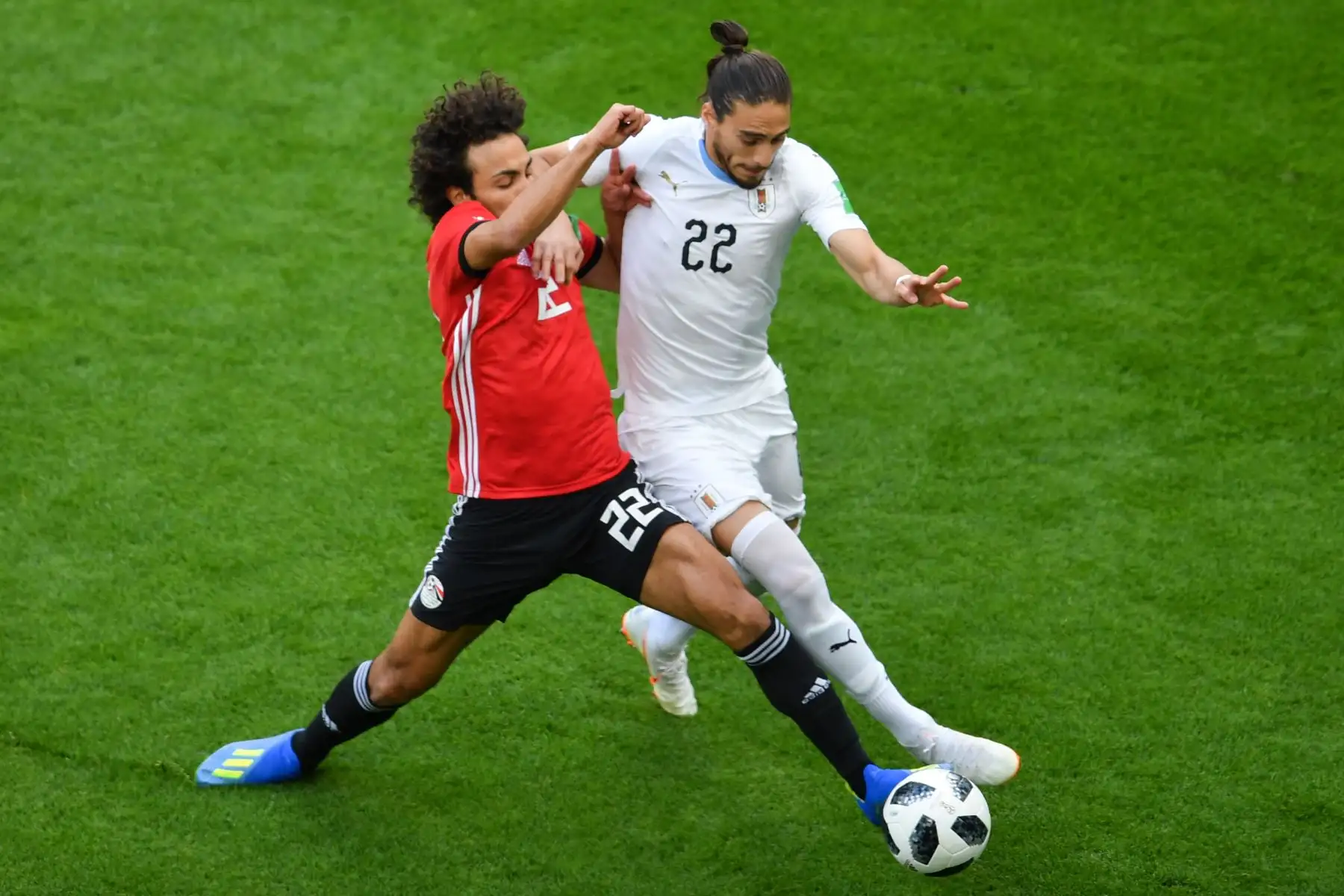 El centrocampista egipcio Amr Warda (L) aborda al defensa uruguayo Martin Cáceres (R) durante el partido de fútbol del Grupo A de la Copa Mundial Rusia 2018. Foto: AFP