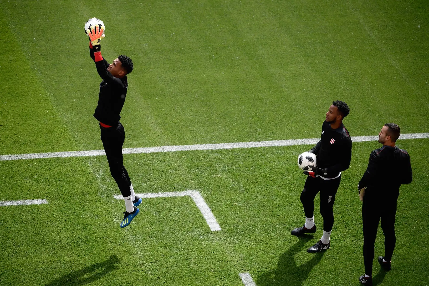 Los arqueros del Perú Carlos Caceda y José Carvallo  miran a su compañero de equipo Pedro Gallese durante una sesión de entrenamiento en el Mordovia Arena en Saransk. Foto: AFP