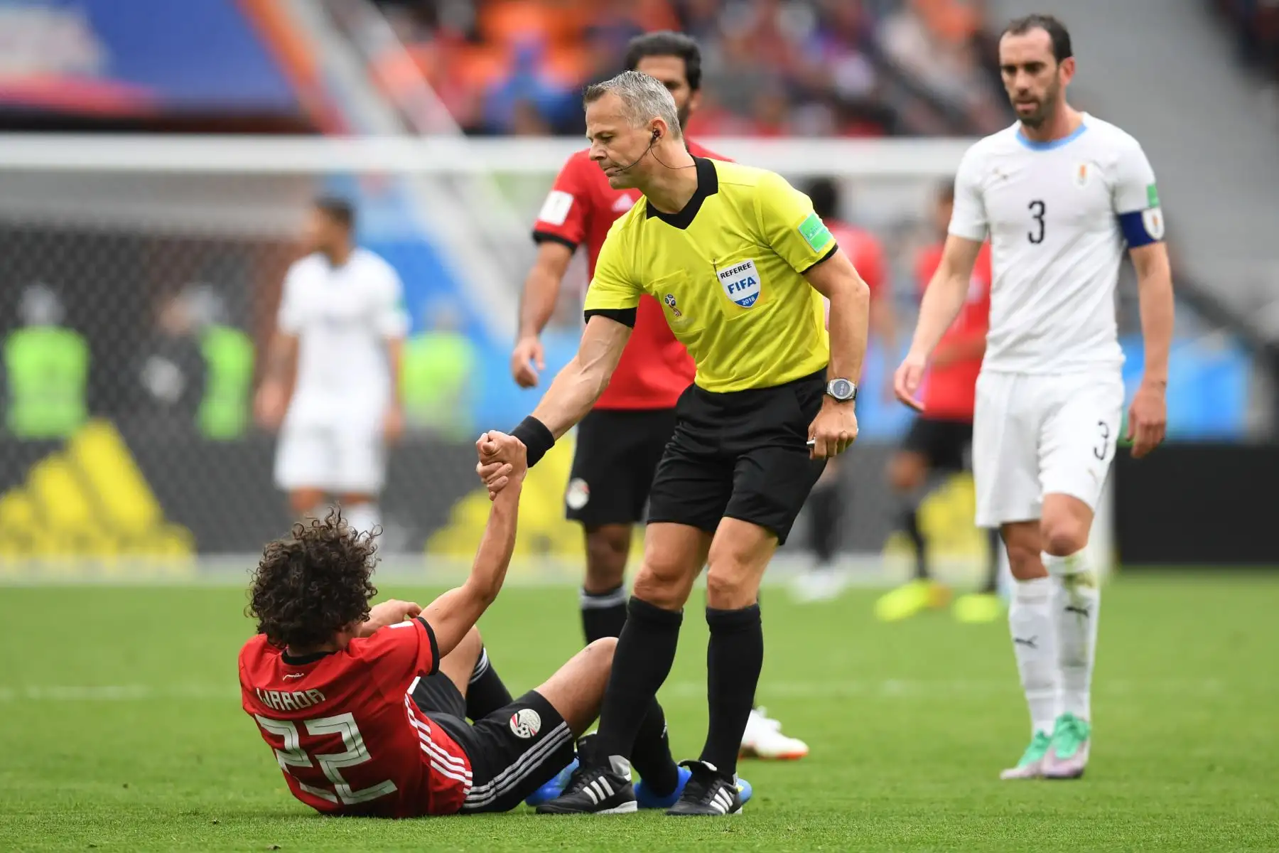 El árbitro holandés Bjorn Kuipers (C) ayuda al centrocampista egipcio Amr Warda (L) durante el partido de fútbol del Grupo A de la Copa Mundial Rusia 2018 entre Egipto y Uruguay en el Ekaterinburg Arena en Ekaterinburg el 15 de junio de 2018. Foto: AFP