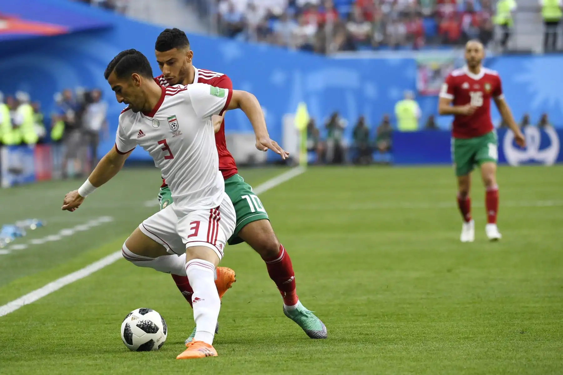 El centrocampista iraní Ehsan Haji Safi (L) reta al centrocampista marroquí Younes Belhanda durante el partido de fútbol del Grupo B de la Copa Mundial Rusia 2018 entre Marruecos e Irán en San Petersburgo. AFP