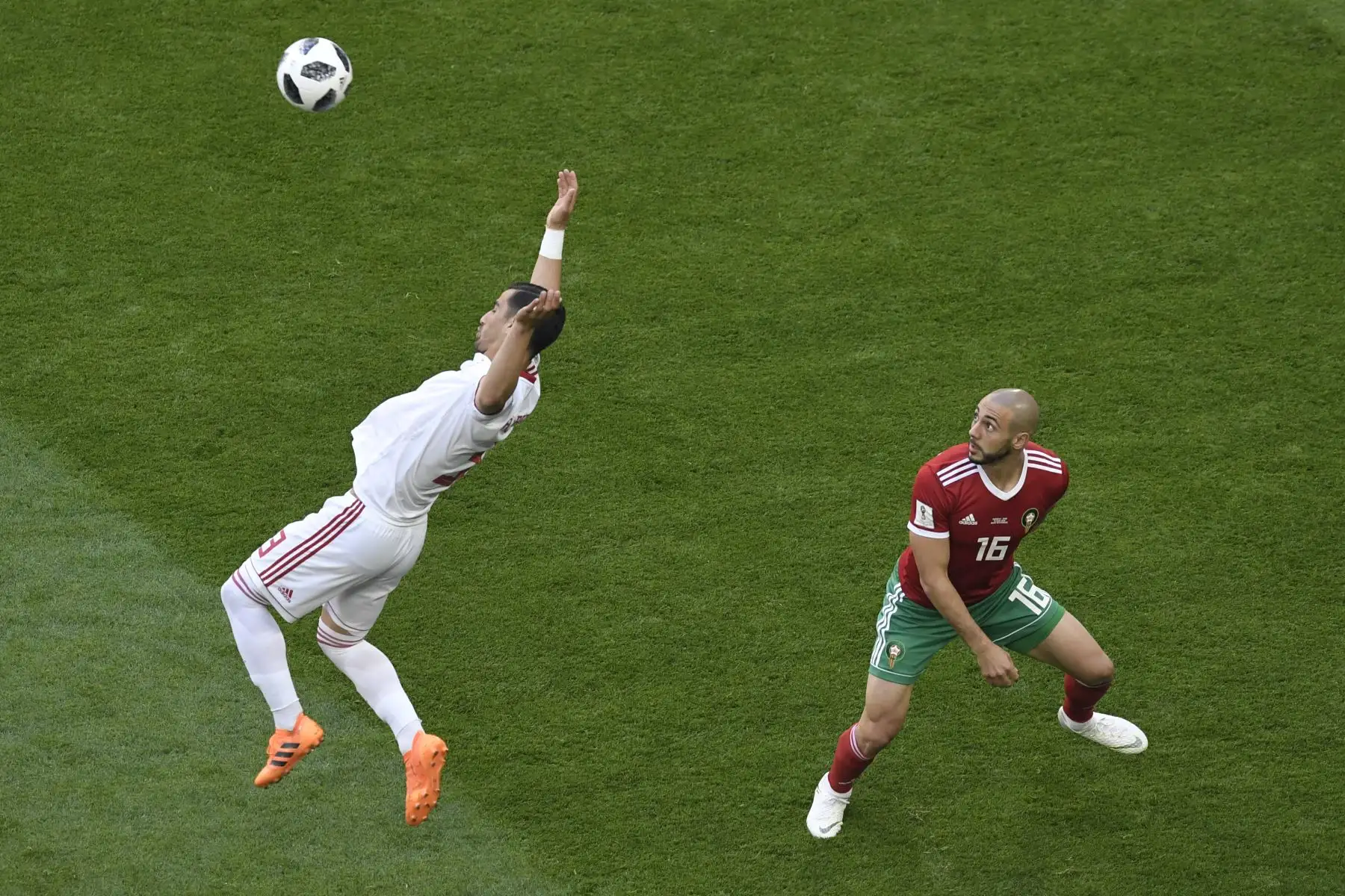 El centrocampista iraní Ehsan Haji Safi (L) compite por el balón con el delantero marroquí Noureddine Amrabat durante el partido de fútbol del Grupo B de la Copa Mundial Rusia 2018 entre Marruecos e Irán en el estadio de San Petersburgo. AFP