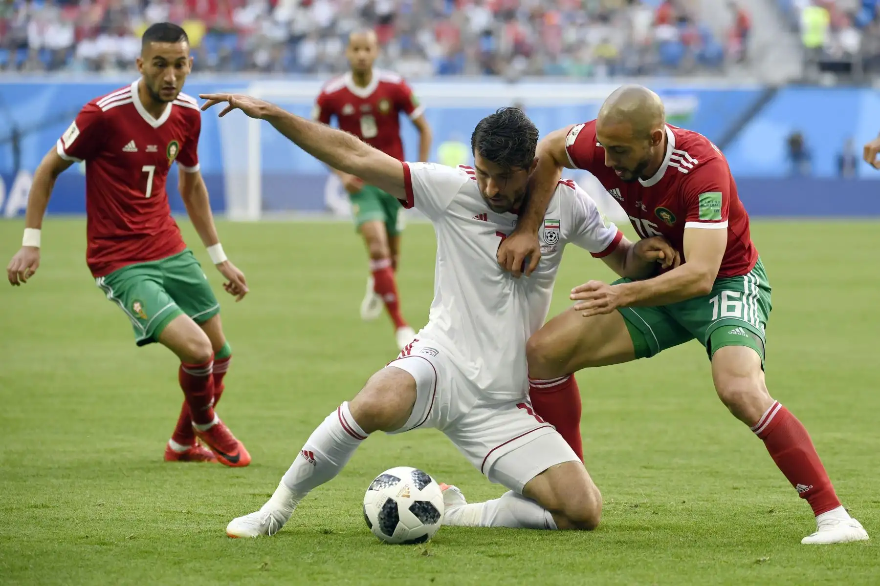 El delantero iraní Karim Ansari Fard (C) desafía al delantero marroquí Noureddine Amrabat (R) y al centrocampista marroquí Hakim Ziyech durante el partido de fútbol del Grupo B de la Copa Mundial Rusia 2018 entre Marruecos e Irán. AFP