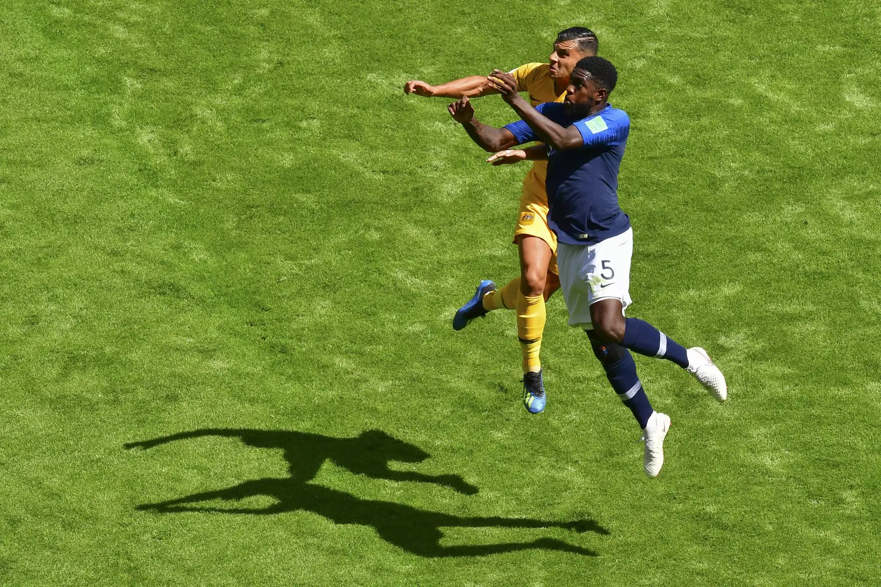 El alero australiano Andrew Nabbout y el defensor de Francia Samuel Umtiti (R) compiten por el cabezazo durante el partido de fútbol del Grupo C de la Copa Rusia 2018 entre Francia y Australia en el Kazan Arena en Kazán el 16 de junio de 2018. Foto: AFP