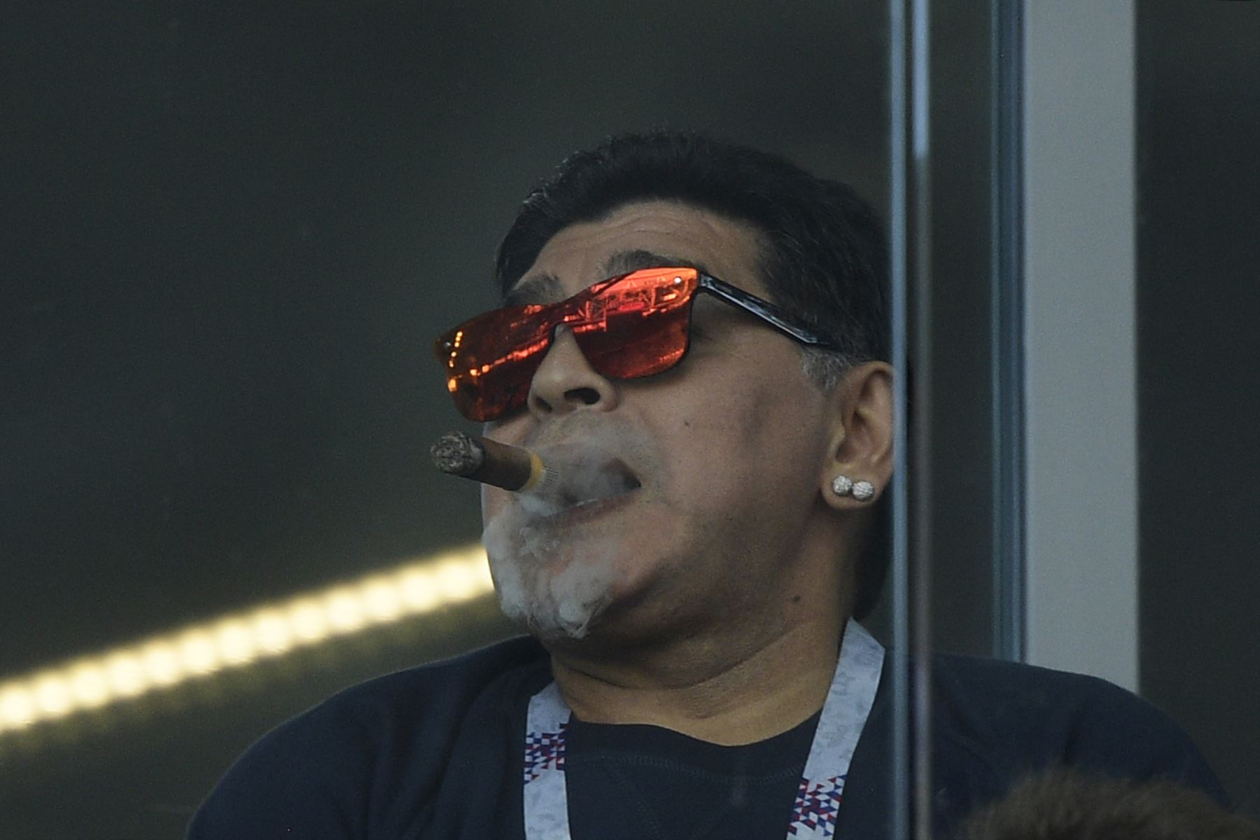 La leyenda del fútbol argentino Diego Maradona fuma un cigarrillo mientras asiste al partido de fútbol del Grupo D de la Copa Mundial Rusia 2018 entre Argentina e Islandia en el Estadio Spartak de Moscú el 16 de junio de 2018. Foto .AFP