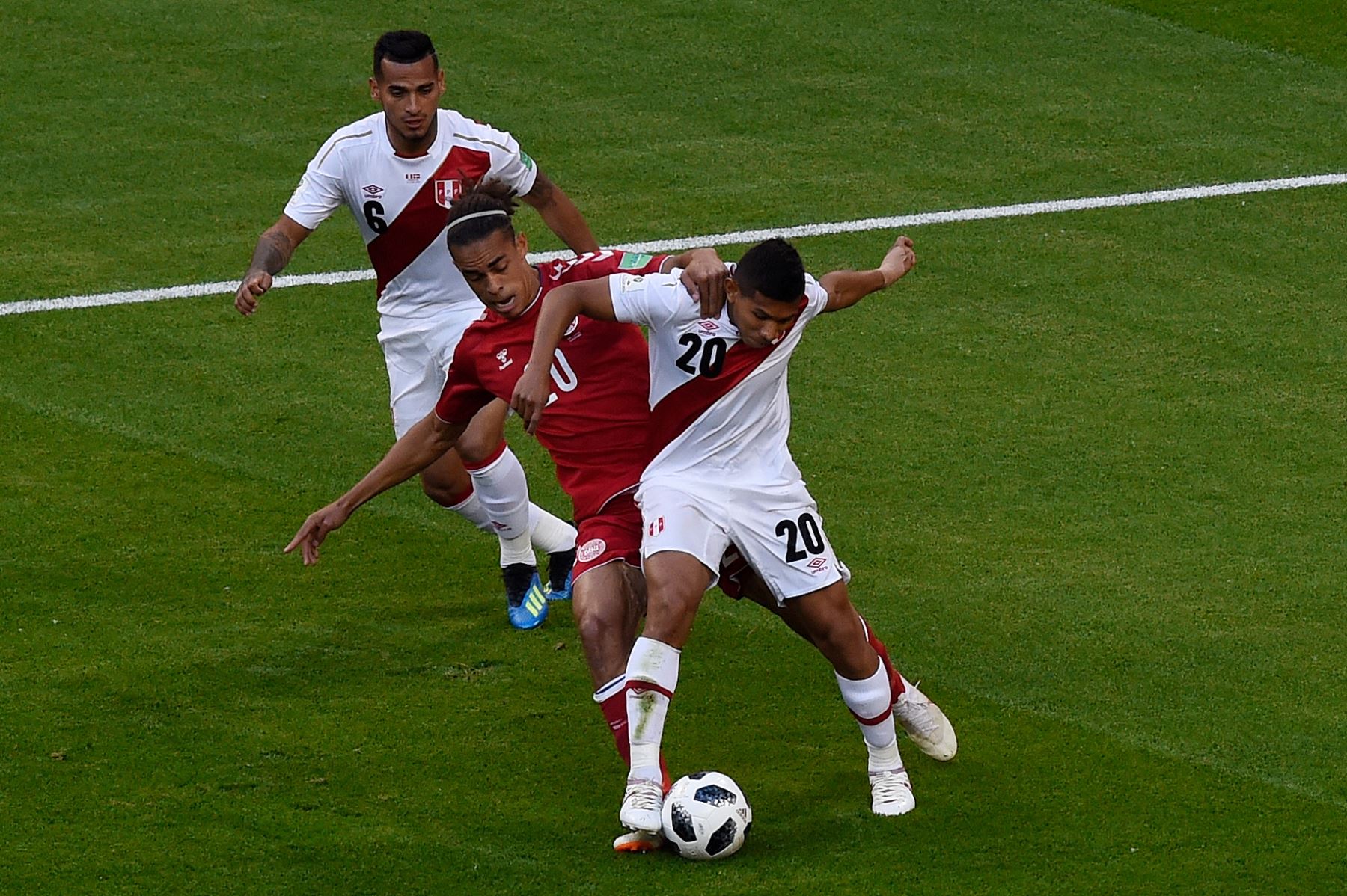 El delantero danés Yussuf Poulsen (C) aborda al centrocampista peruano Edison Flores (R) durante el partido de fútbol del Grupo C de la Copa Mundial Rusia 2018 entre Perú y Dinamarca en el Mordovia Arena en Saransk el 16 de junio de 2018. Foto: AFP