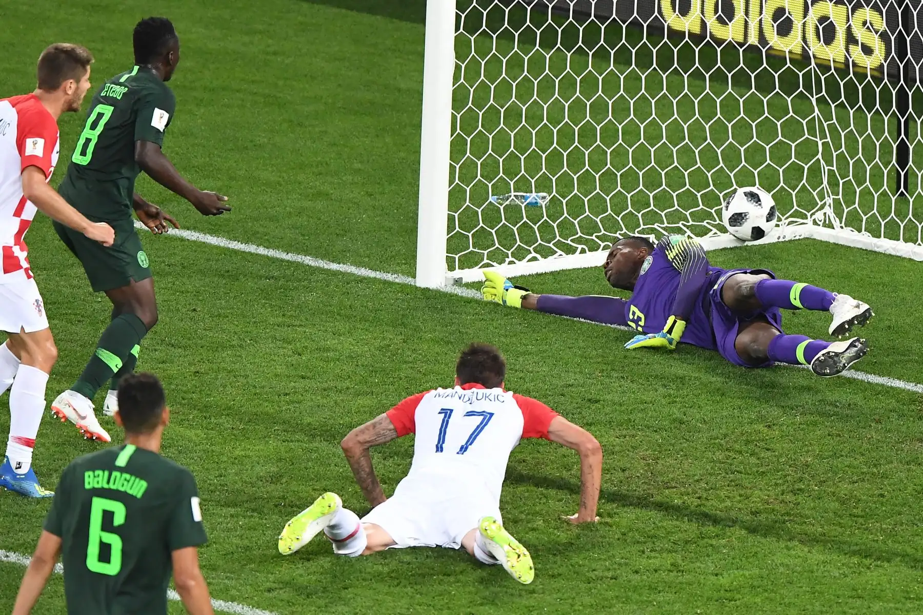 El delantero croata Mario Mandzukic (R) y el mediocampista de Nigeria Oghenekaro Etebo (2ndL) anotan un gol en contra del portero de Nigeria Francis Uzoho durante el partido de fútbol del Grupo D de la Copa Mundial Rusia 2018 entre Croacia y Nigeria en el Estadio de Kaliningrado en Kaliningrado el 16 de junio. 2018. / AFP