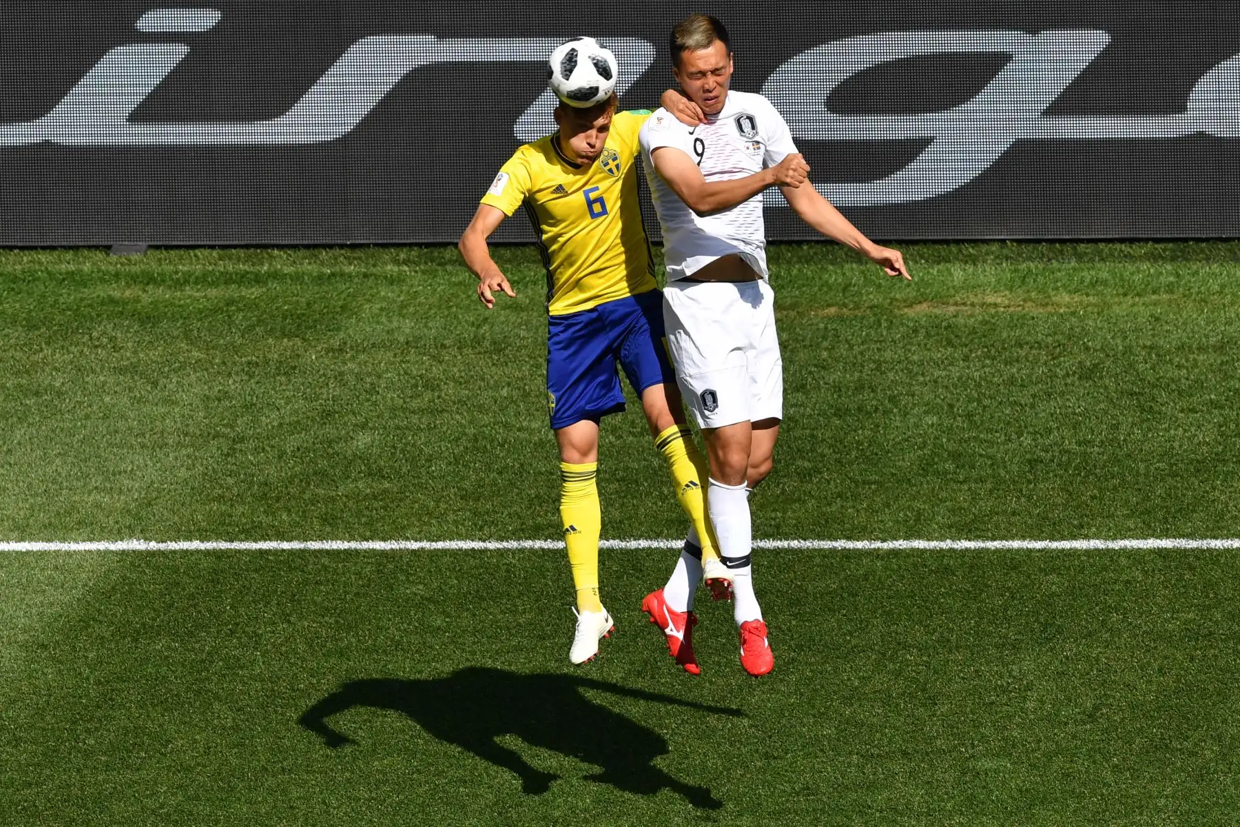El alero surcoreano Kim Shin-wook  compite por el cabezazo con el defensa sueco Ludwig Augustinsson durante el partido de fútbol del Grupo F de la Copa Mundial Rusia 2018 entre Suecia y Corea del Sur en el Estadio Nizhny Novgorod en Nizhny Novgorod. Foto: AFP