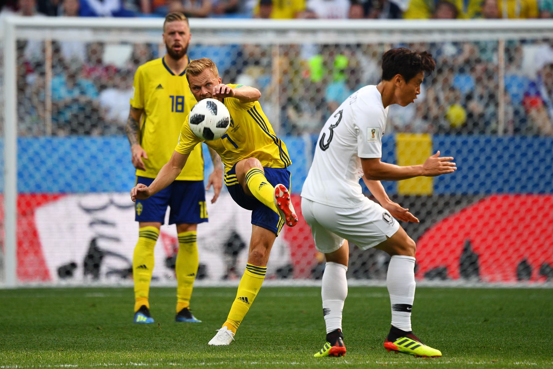 El mediocampista sueco Sebastian Larsson (C) intenta un pase ya que está marcado por el mediocampista coreano Koo Ja-cheol (R) durante el partido de fútbol del Grupo F de la Copa Mundial Rusia 2018 entre Suecia y Corea del Sur en el Estadio Nizhny Novgorod. AFP