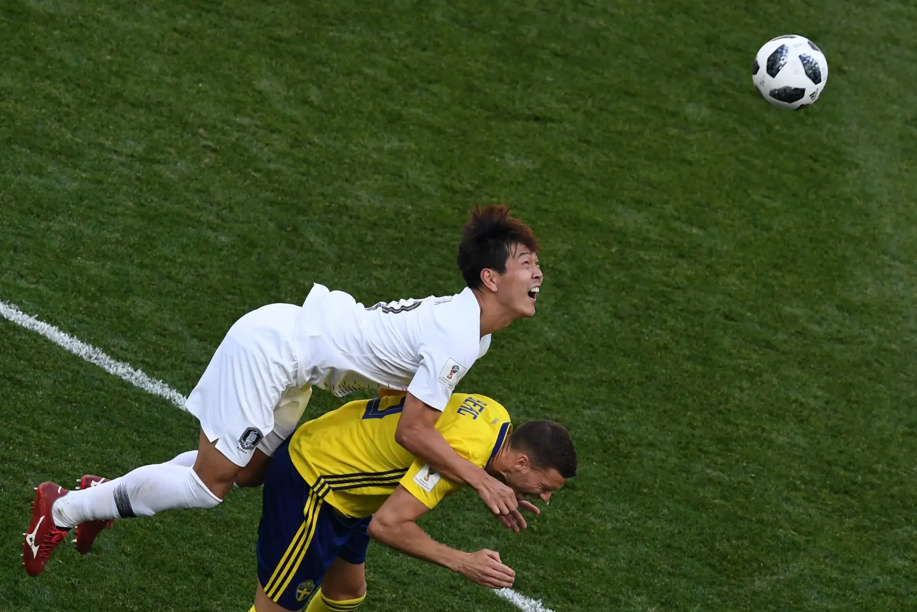 El defensa surcoreano Kim Young-gwon (L) compite por el cabezazo con el delantero sueco Marcus Berg durante el partido de fútbol del Grupo F de la Copa Mundial Rusia 2018 entre Suecia y Corea del Sur. AFP