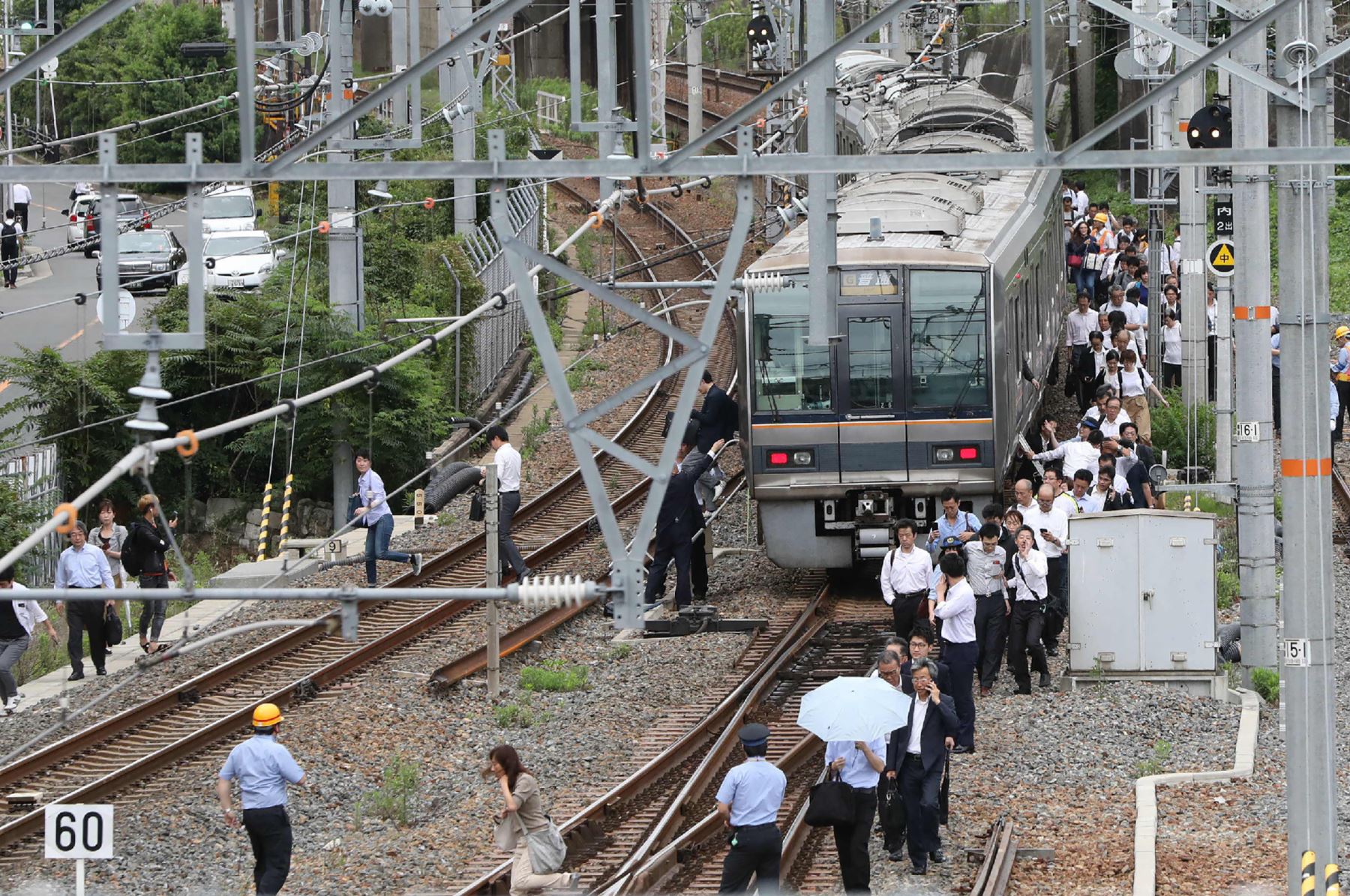 Los pasajeros de un tren caminan por las vías del tren después de un terremoto en Osaka el 18 de junio de 2018. Un fuerte sismo sacudió el oeste de Japón a principios del 18 de junio, pero no hubo informes inmediatos de mayor daño o riesgo de olas de tsunami, dijeron las autoridades.Foto: AFP
