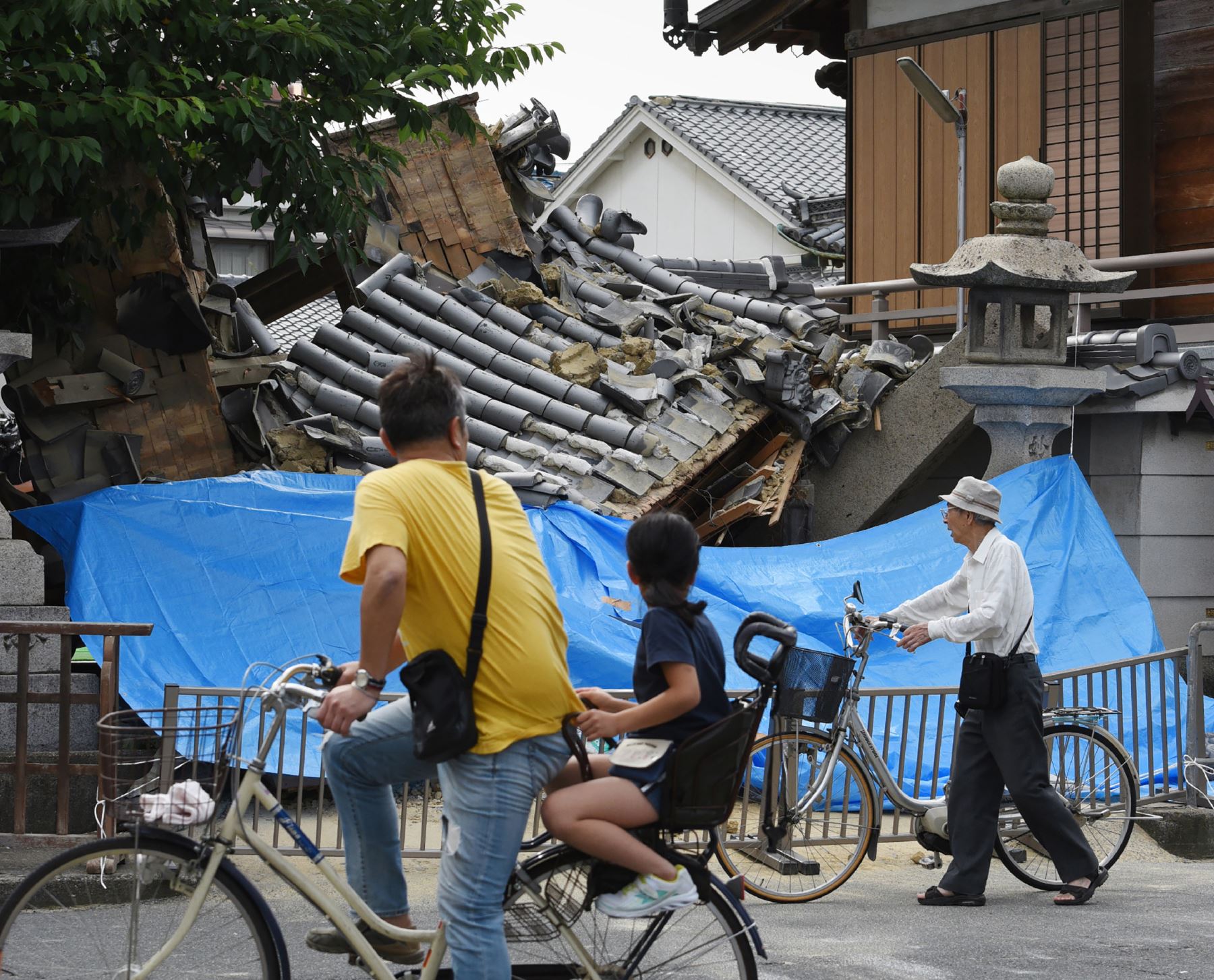 La gente hace una pausa para mirar una casa derrumbada después de un terremoto en la ciudad de Ibaraki, al norte de la prefectura de Osaka.Foto.AFP