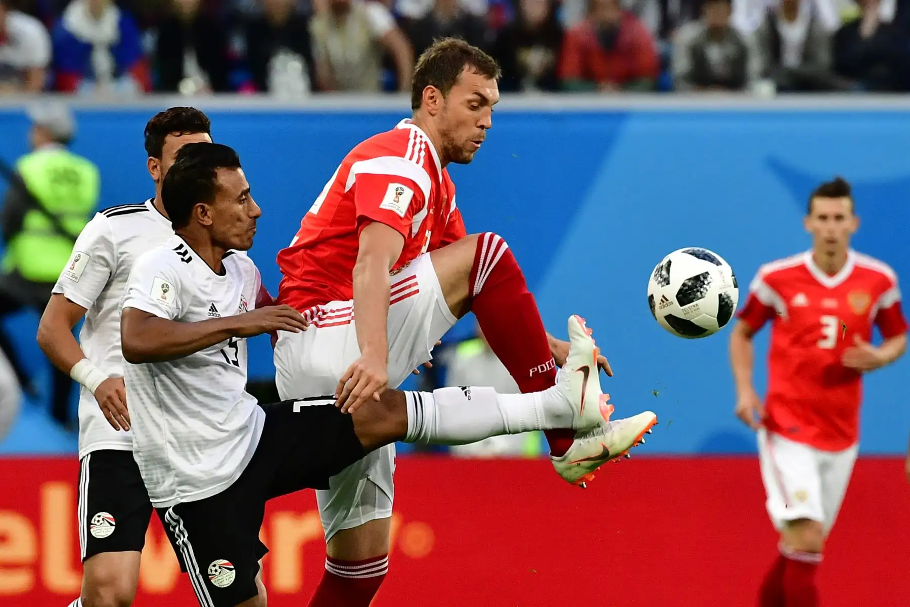 El defensor de Egipto Mohamed Abdel-Shafy compite con el delantero ruso Artem Dzyuba durante el partido de fútbol Rusia A del Grupo A de la Copa Mundial 2018 entre Rusia y Egipto en el estadio de San Petersburgo el 19 de junio de 2018. / AFP