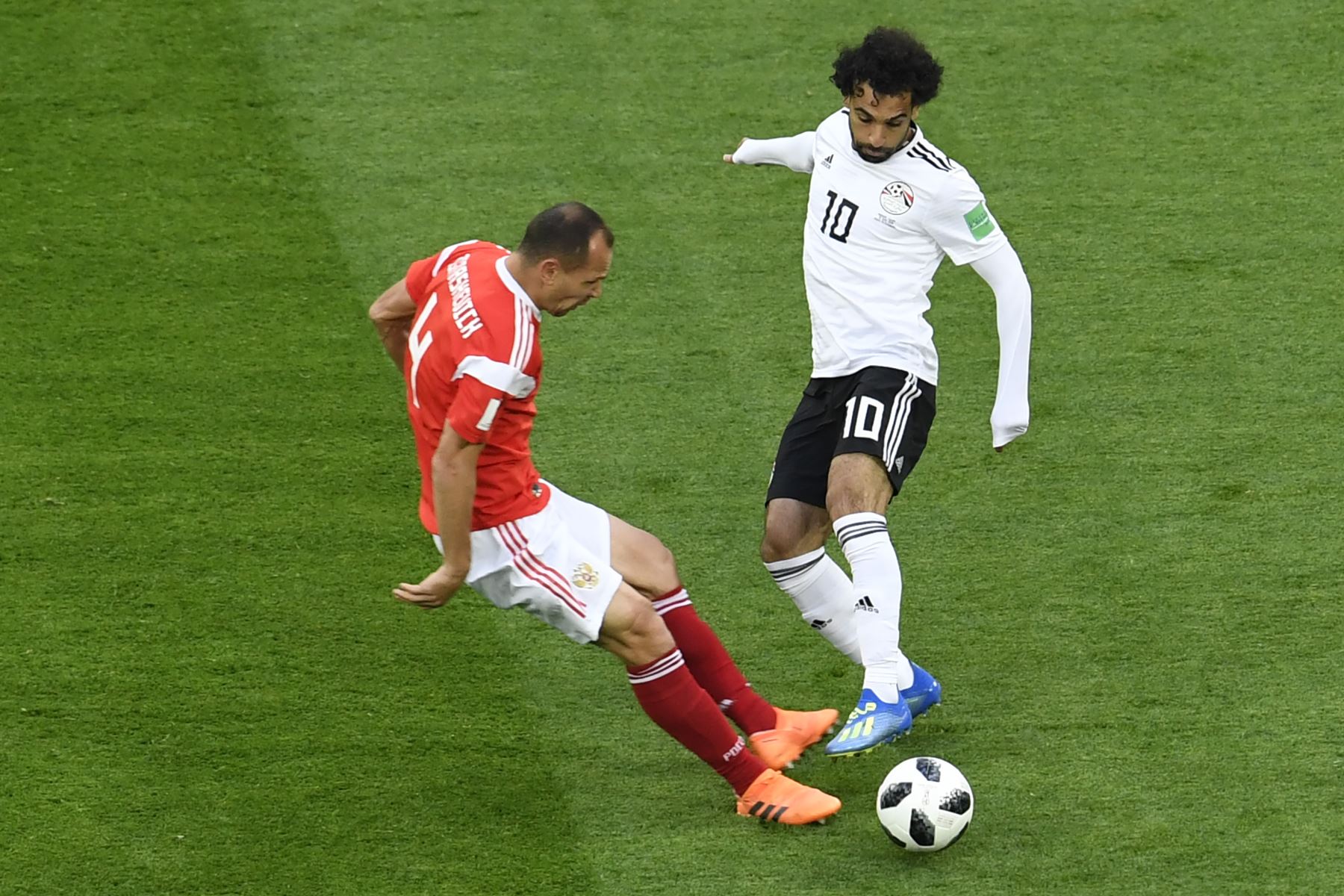 El delantero egipcio Mohamed Salah (R) regatea al defensor ruso Sergey Ignashevich durante el partido de fútbol del Grupo A de la Copa Mundial Rusia 2018 entre Rusia y Egipto en el estadio San Petersburgo de San Petersburgo el 19 de junio de 2018. / AFP