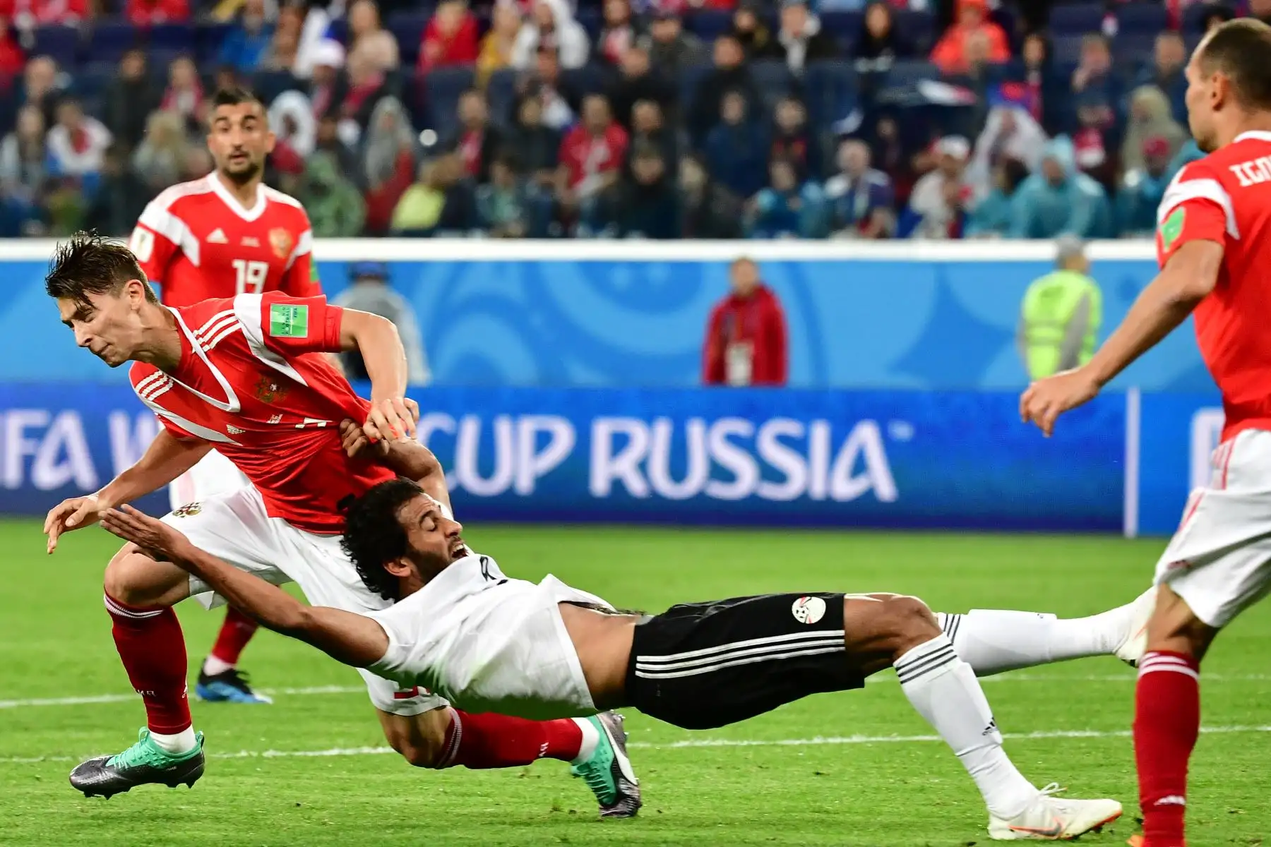 La defensora rusa Ilja Kutepov (L) lucha por el balón con el delantero de Egipto Marwan Mohsen durante el partido de fútbol Rusia A del Grupo A de la Copa Mundial 2018 entre Rusia y Egipto en el Estadio de San Petersburgo el 19 de junio de 2018. / AFP