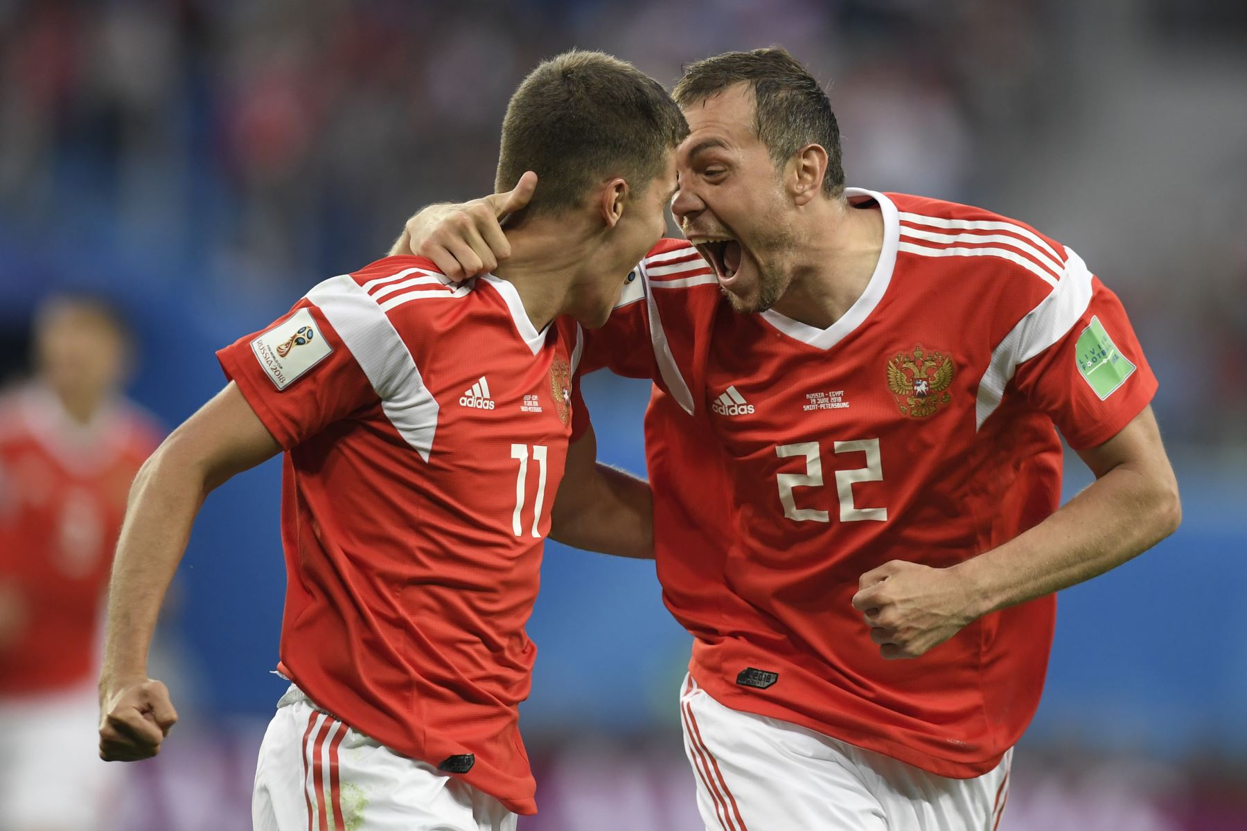 El delantero ruso Artem Dzyuba y el portero egipcio Sherif Ekramy celebran el gol de apertura durante el partido de fútbol Rusia A del Grupo A de la Copa Mundial 2018 entre Rusia y Egipto en el estadio de San Petersburgo el 19 de junio de 2018. / AFP