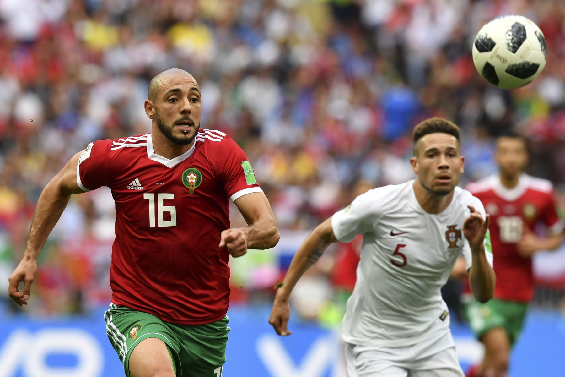El delantero marroquí Noureddine Amrabat (L) y el defensor portugués Raphael Guerreiro (R) observan el balón mientras corren durante el partido de fútbol del Grupo B de la Copa Mundial Rusia 2018 entre Portugal y Marruecos en el Estadio Luzhniki en Moscú el 20 de junio de 2018. / AFP