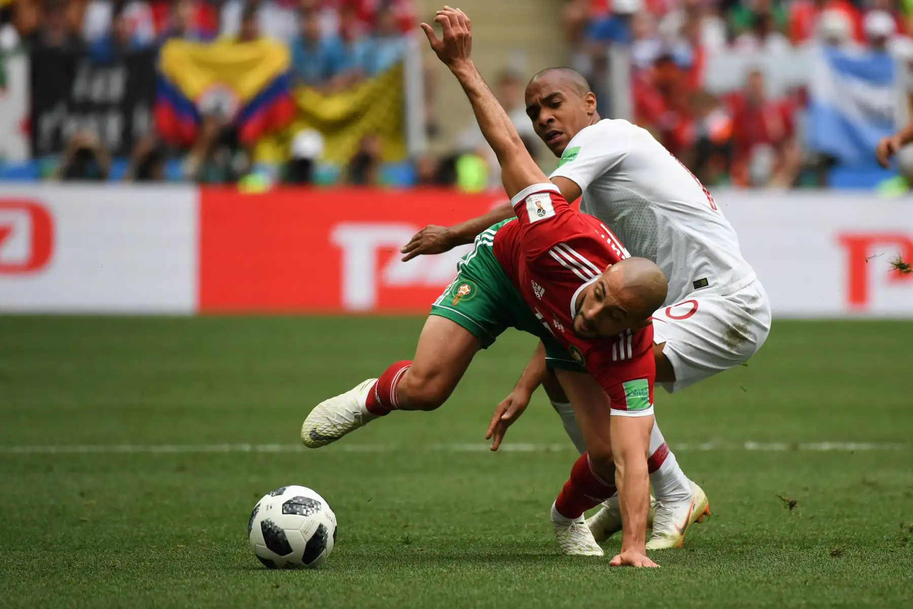 El delantero marroquí Noureddine Amrabat (L) compite por el balón con el centrocampista portugués Joao Mario mientras lo observa durante el partido de fútbol del Grupo B de la Copa Mundial Rusia 2018 entre Portugal y Marruecos en el Estadio Luzhniki de Moscú el 20 de junio de 2018. / AFP
