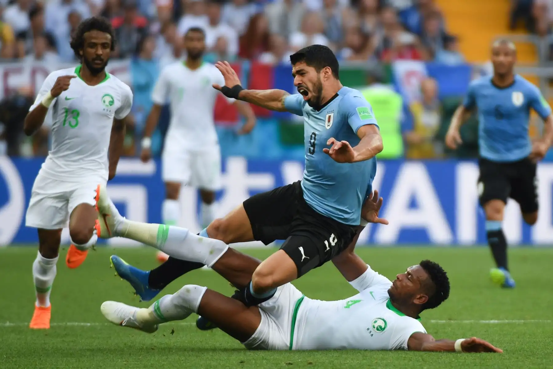 El defensor de Arabia Saudita Ali Al-Bulaihi (ABAJO) aborda al delantero uruguayo Luis Suárez durante el partido de fútbol del Grupo A de la Copa Mundial Rusia 2018 entre Uruguay y Arabia Saudita en el Rostov Arena en Rostov-On-Don el 20 de junio de 2018. / AFP