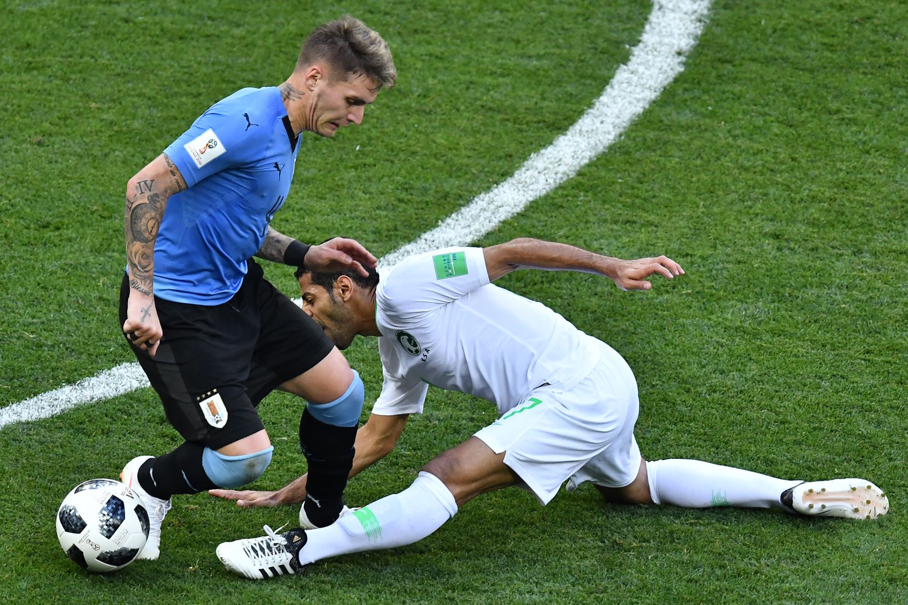 El centrocampista de Arabia Saudita Taisir Al-Jassim (R) se hiere mientras lucha por el balón con el defensor uruguayo Guillermo Varela durante el partido de fútbol del Grupo A de la Copa Mundial Rusia. AFP
